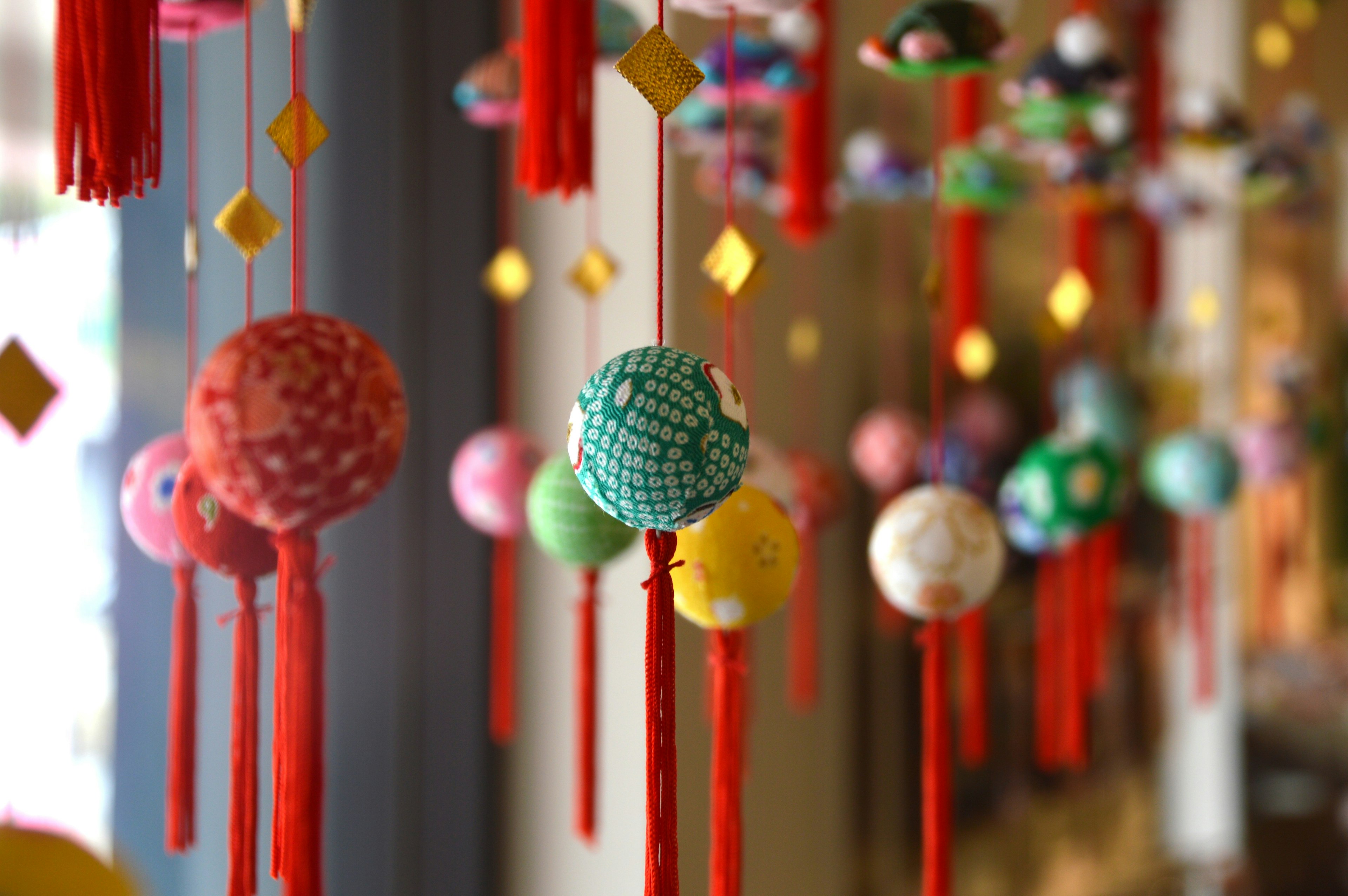 Bolas decorativas coloridas con borlas rojas colgando en una exhibición vibrante