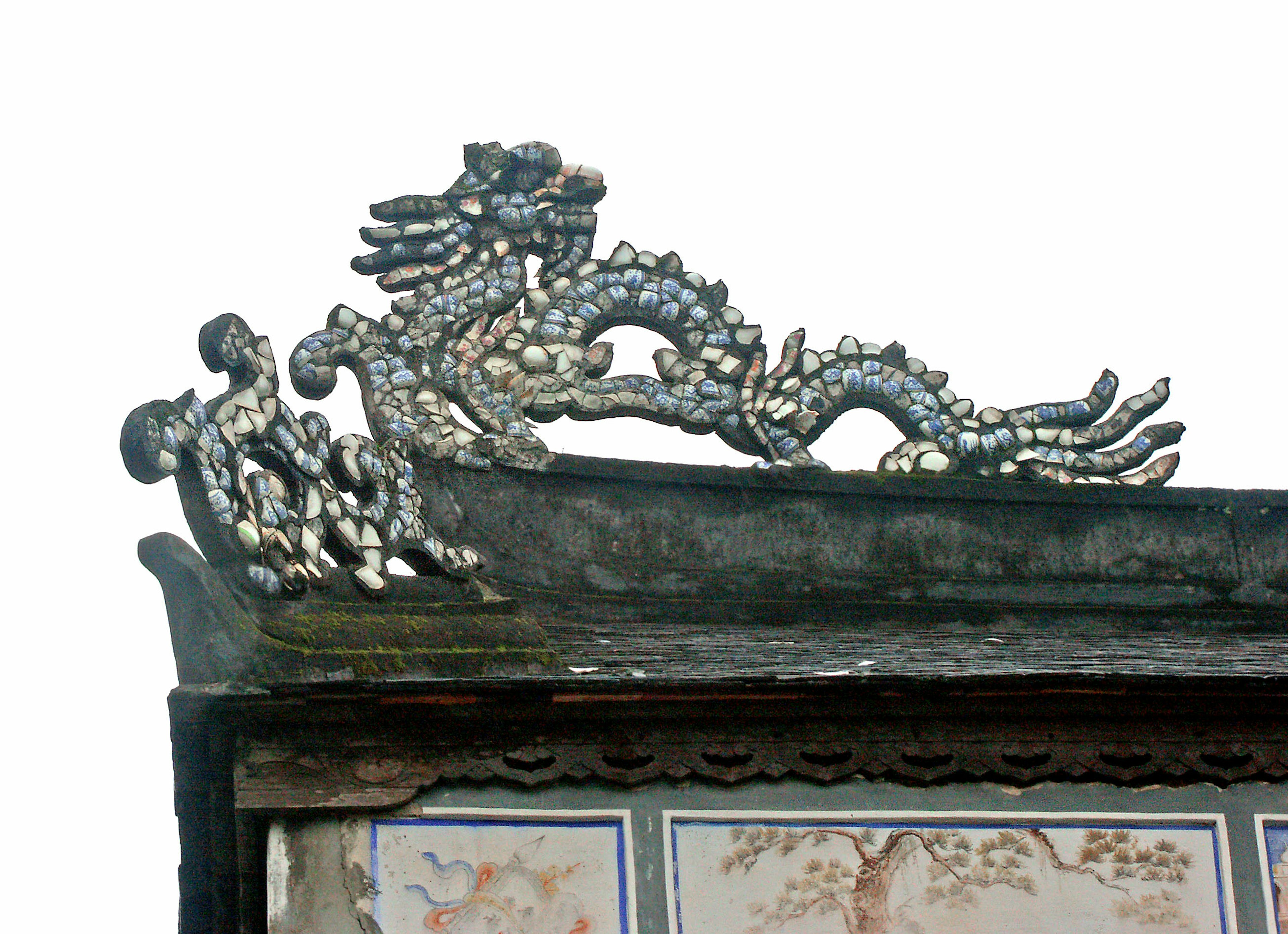 Decorative dragon sculpture with cloud designs on a roof