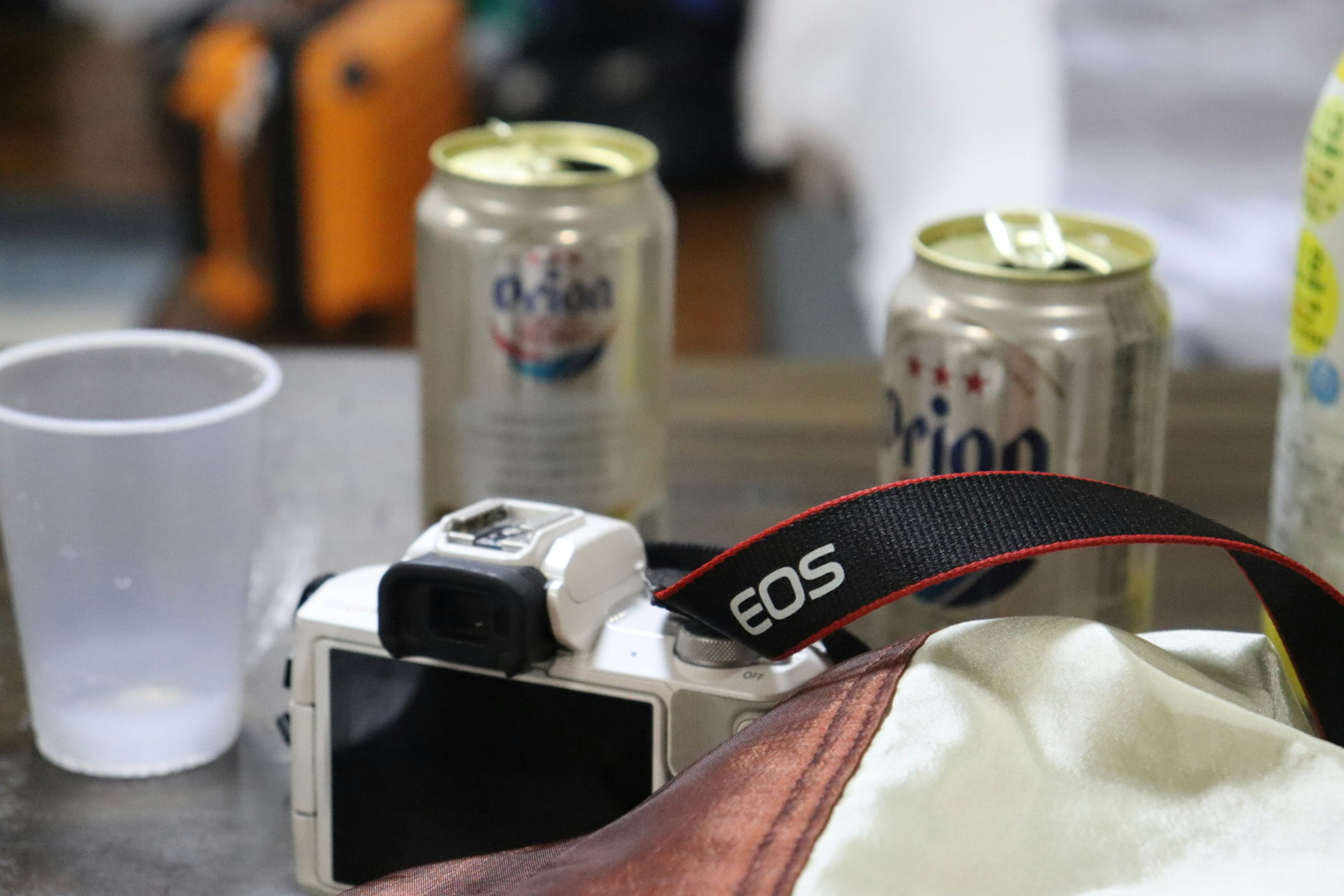 A camera and beverage cans on a table