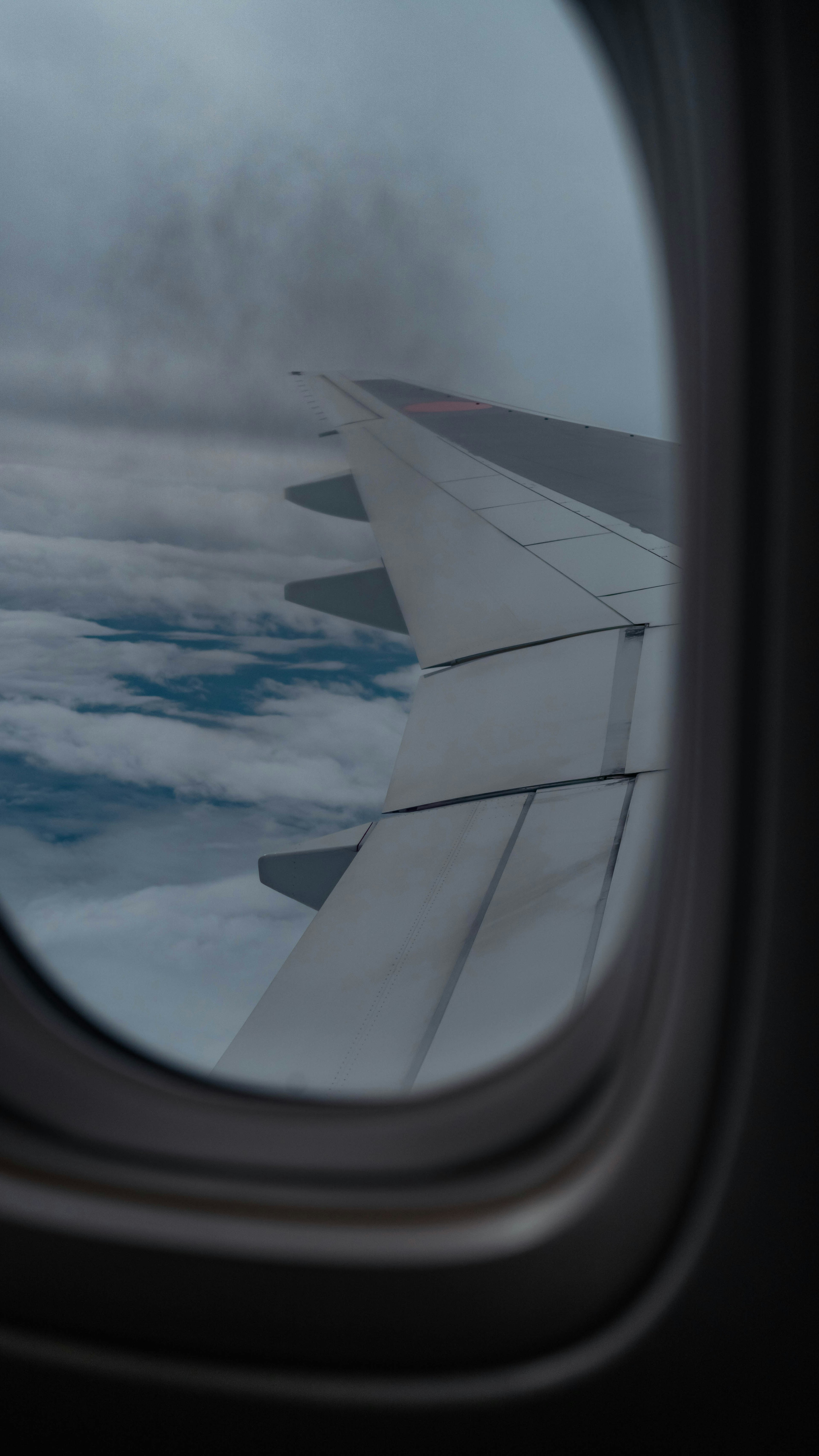 飛行機の窓から見える翼と雲の景色