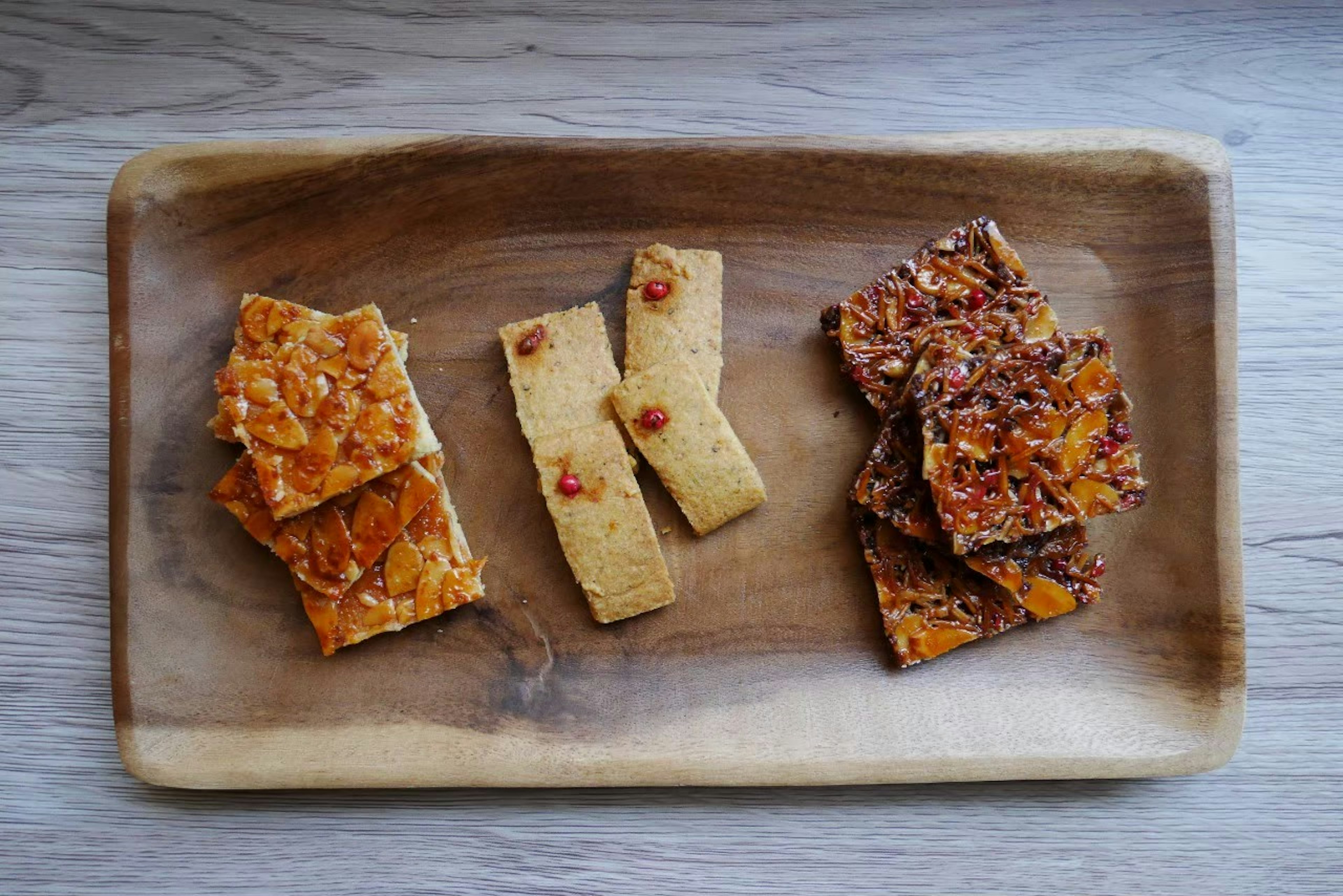 Friandises à base de noix et de caramel disposées sur une assiette en bois