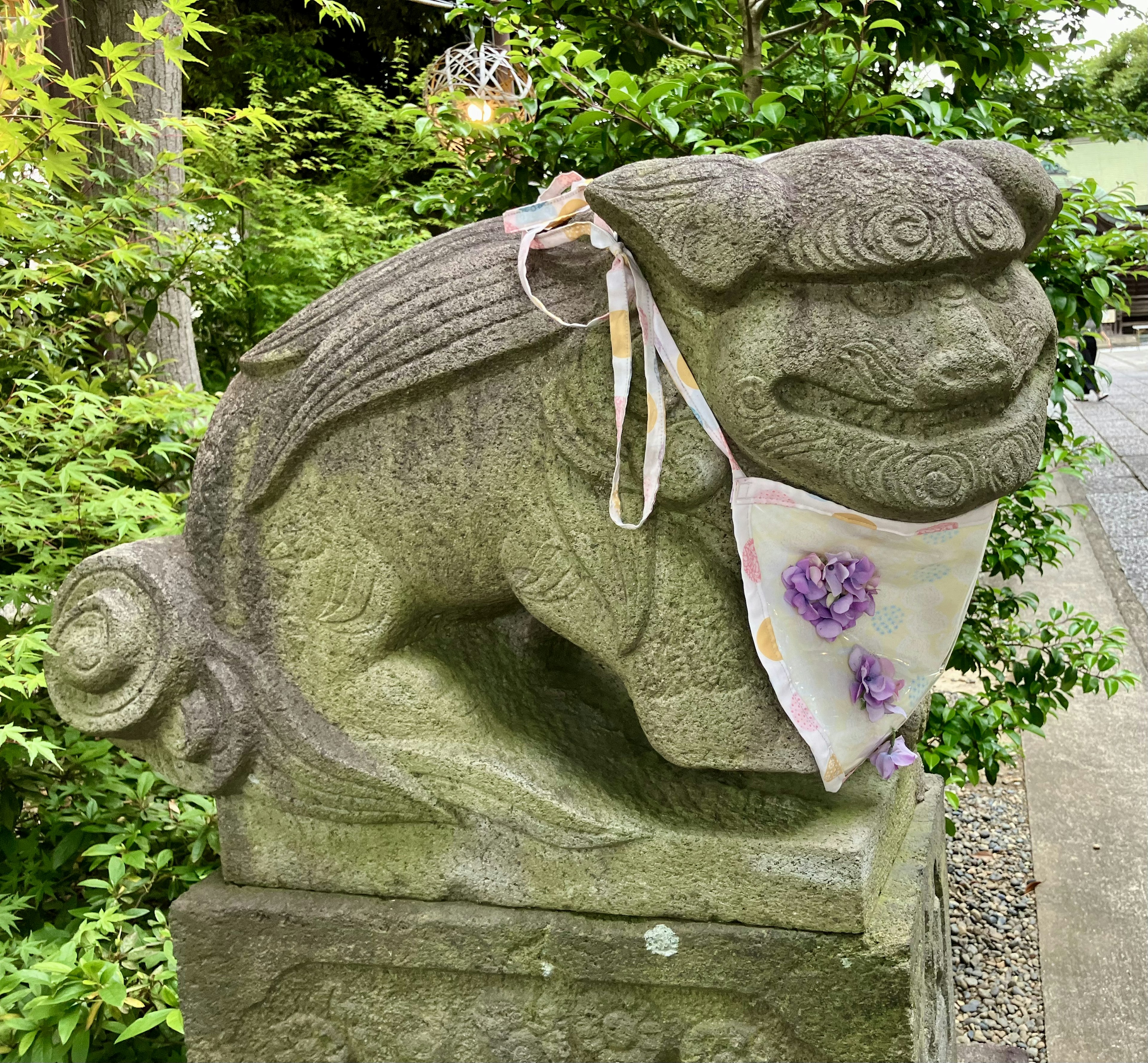 León guardián de piedra con una bufanda decorada alrededor del cuello