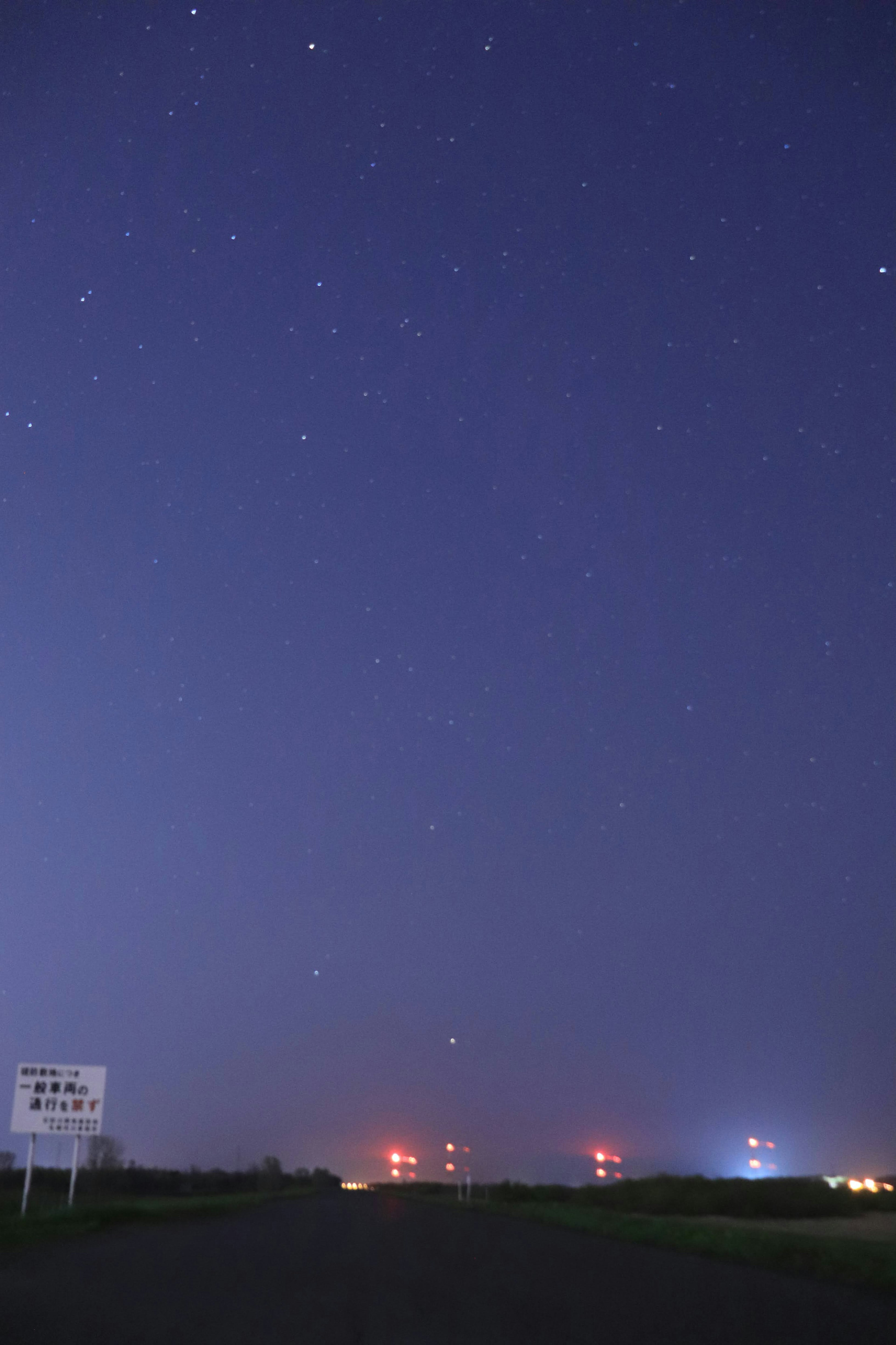 夜空中布滿星星，紅色和藍色的燈塔