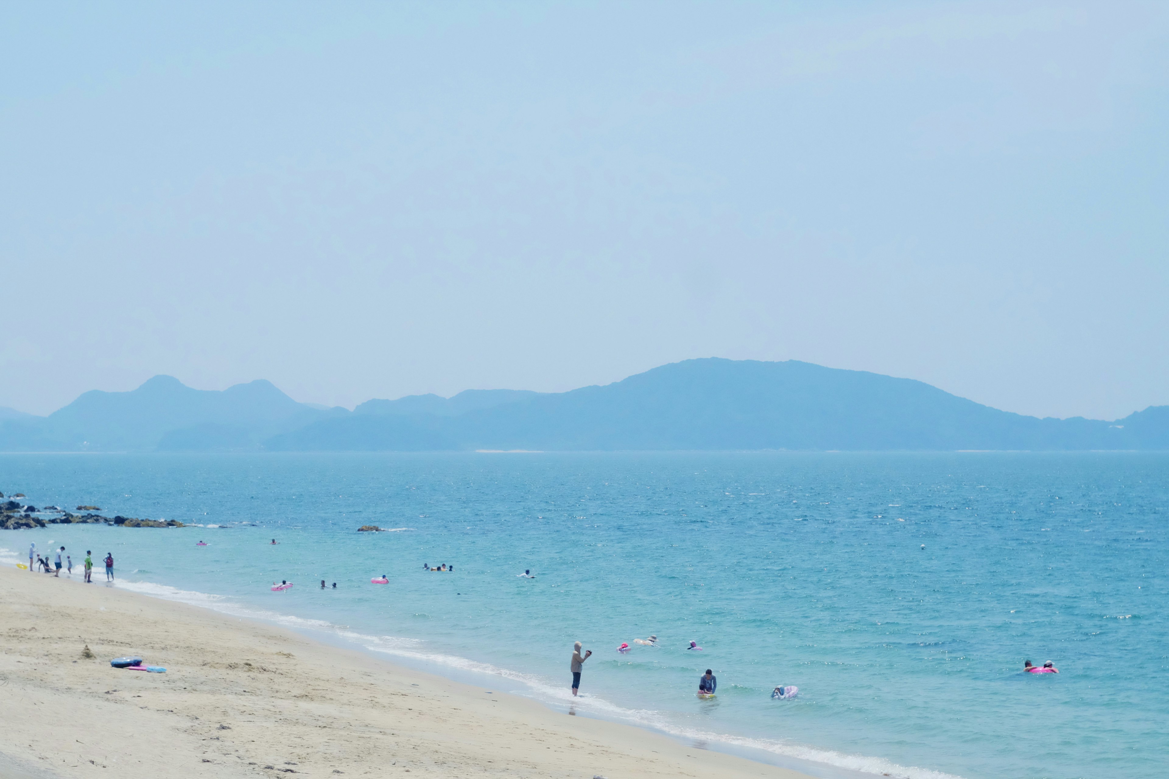 ทิวทัศน์ชายหาดที่มีทะเลสีน้ำเงินและชายฝั่งทราย