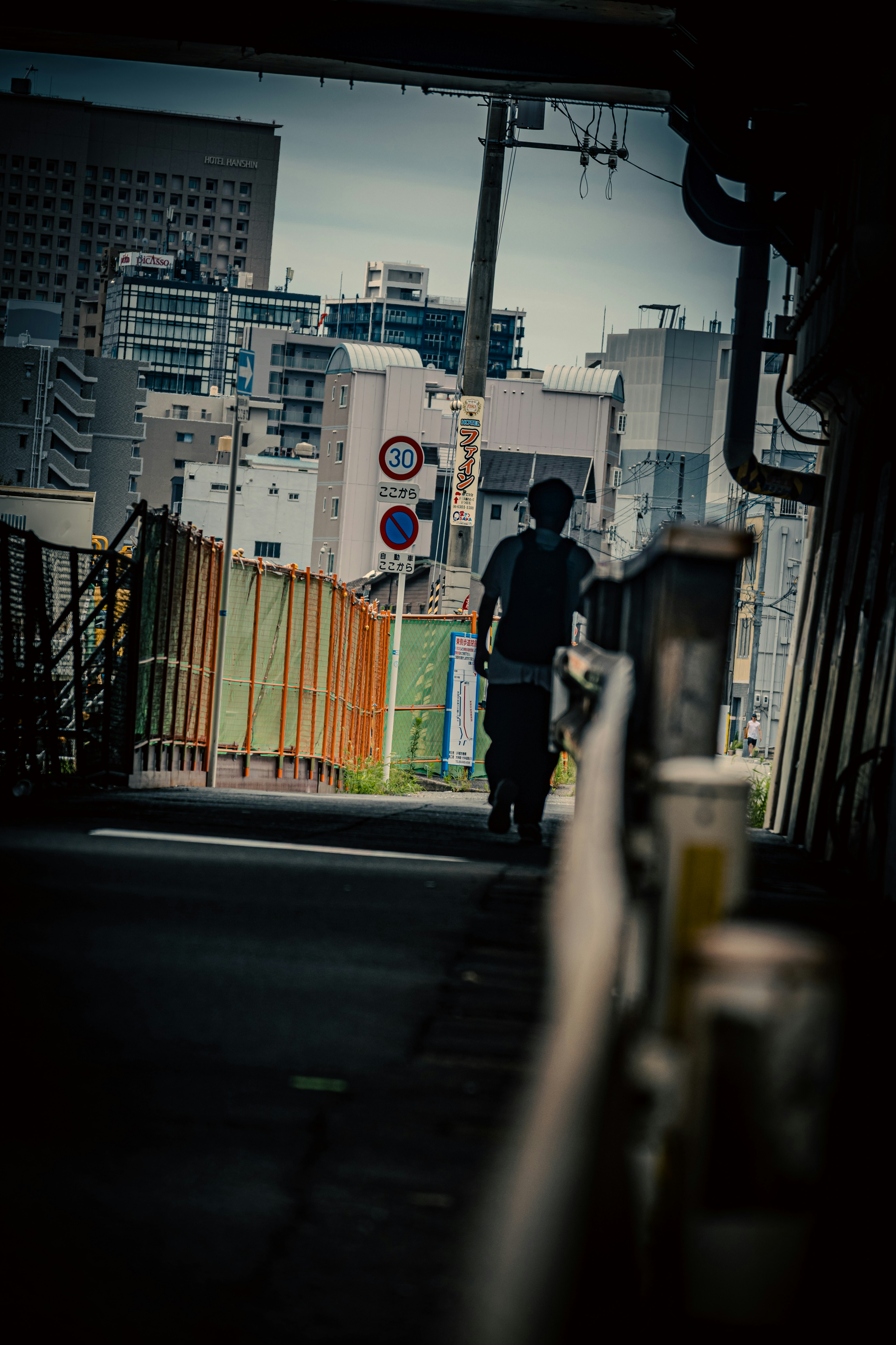 都市の風景の中を歩く人物のシルエット