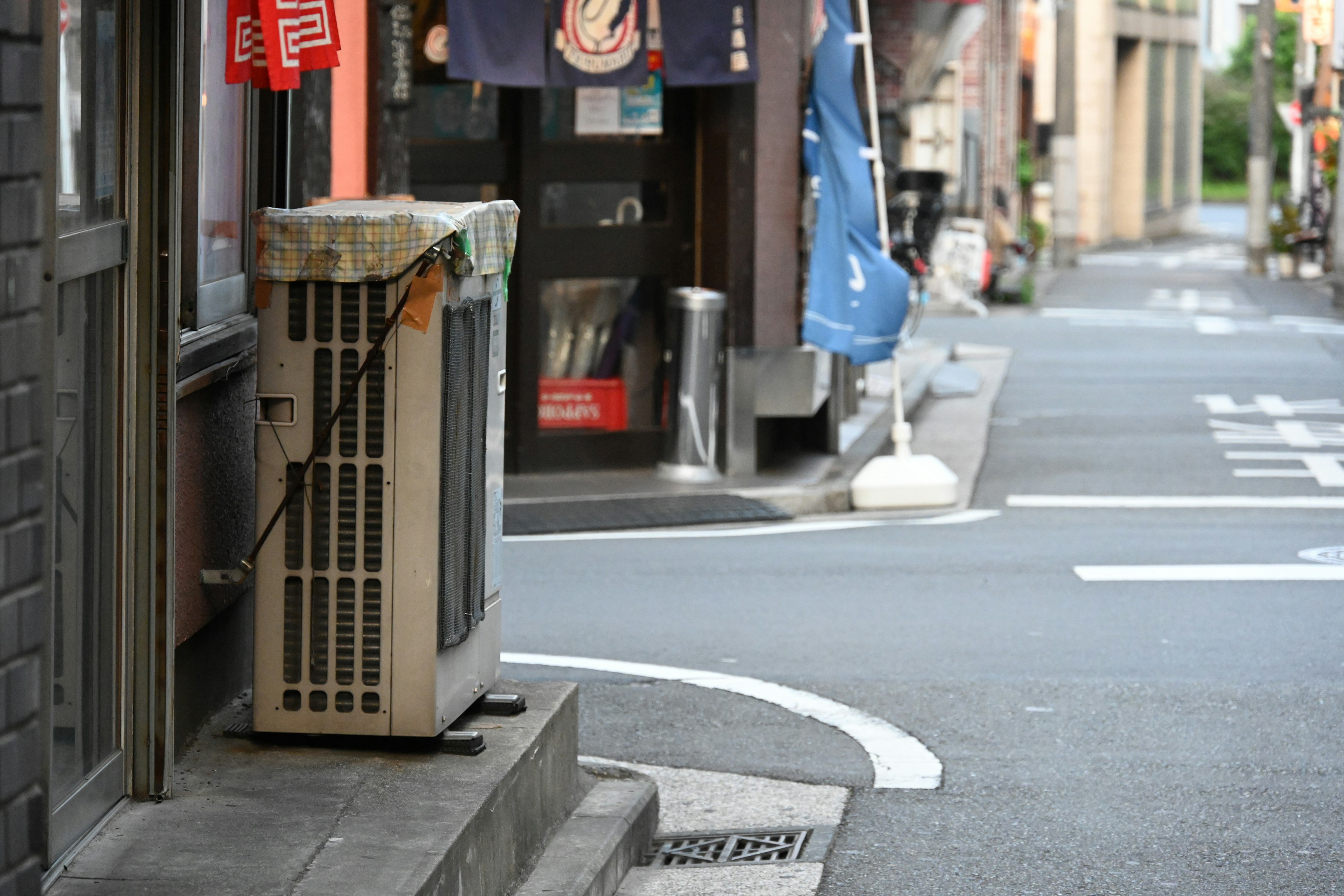 Klimaanlage in einer Gasse mit nahegelegenen Geschäften