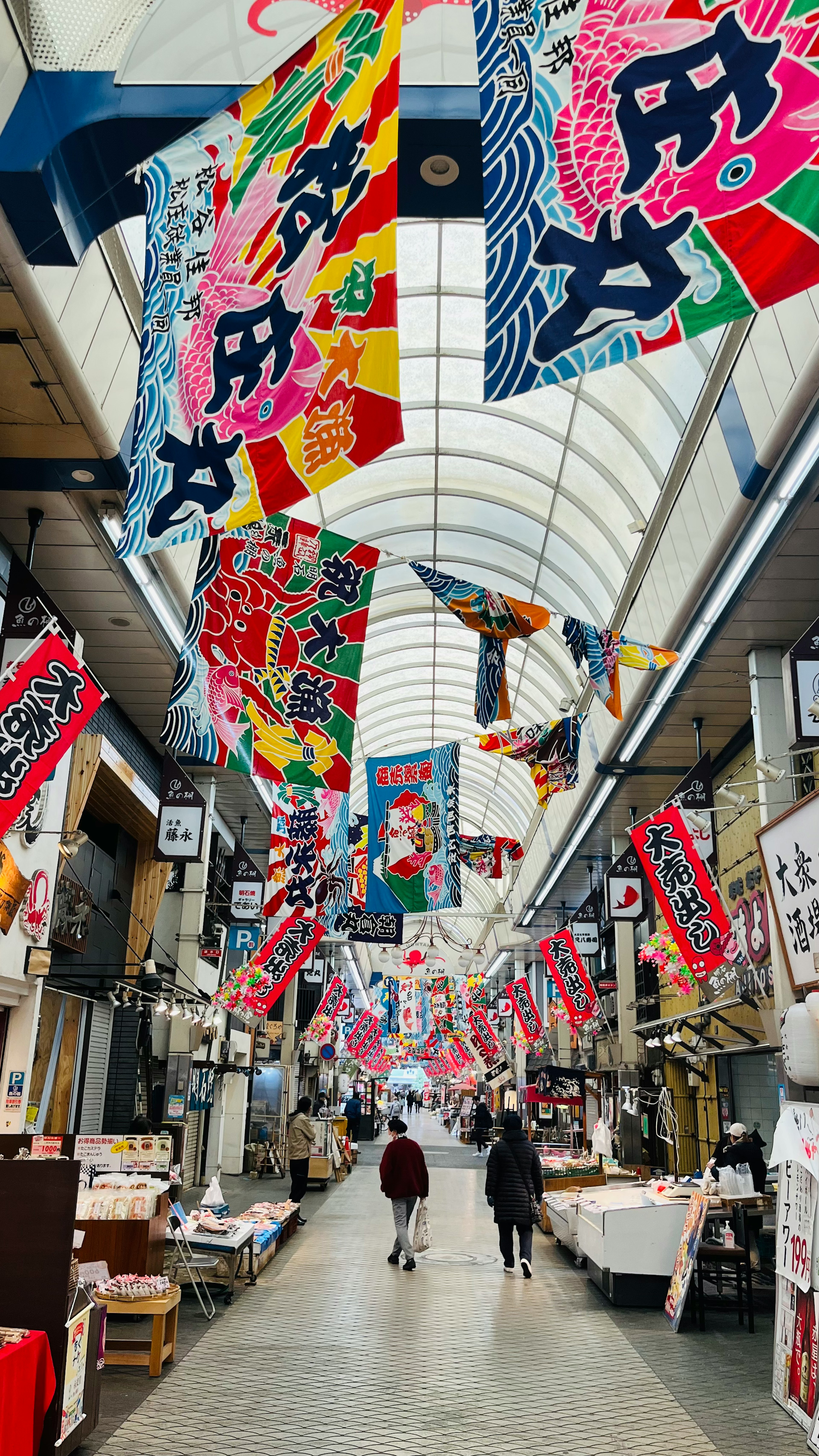 色とりどりののぼりが飾られた日本の商店街の通り