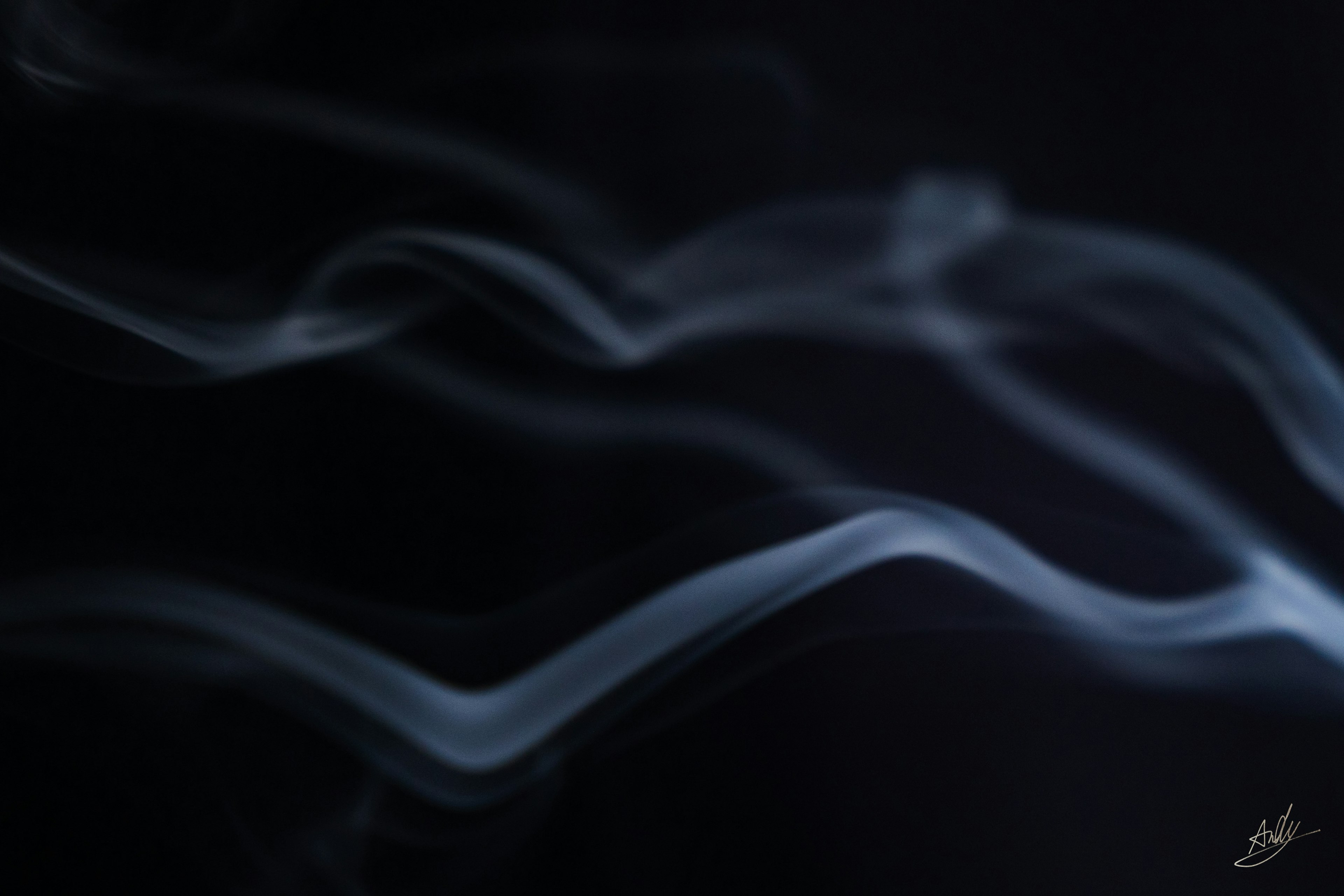 Flowing wisps of pale blue smoke against a black background