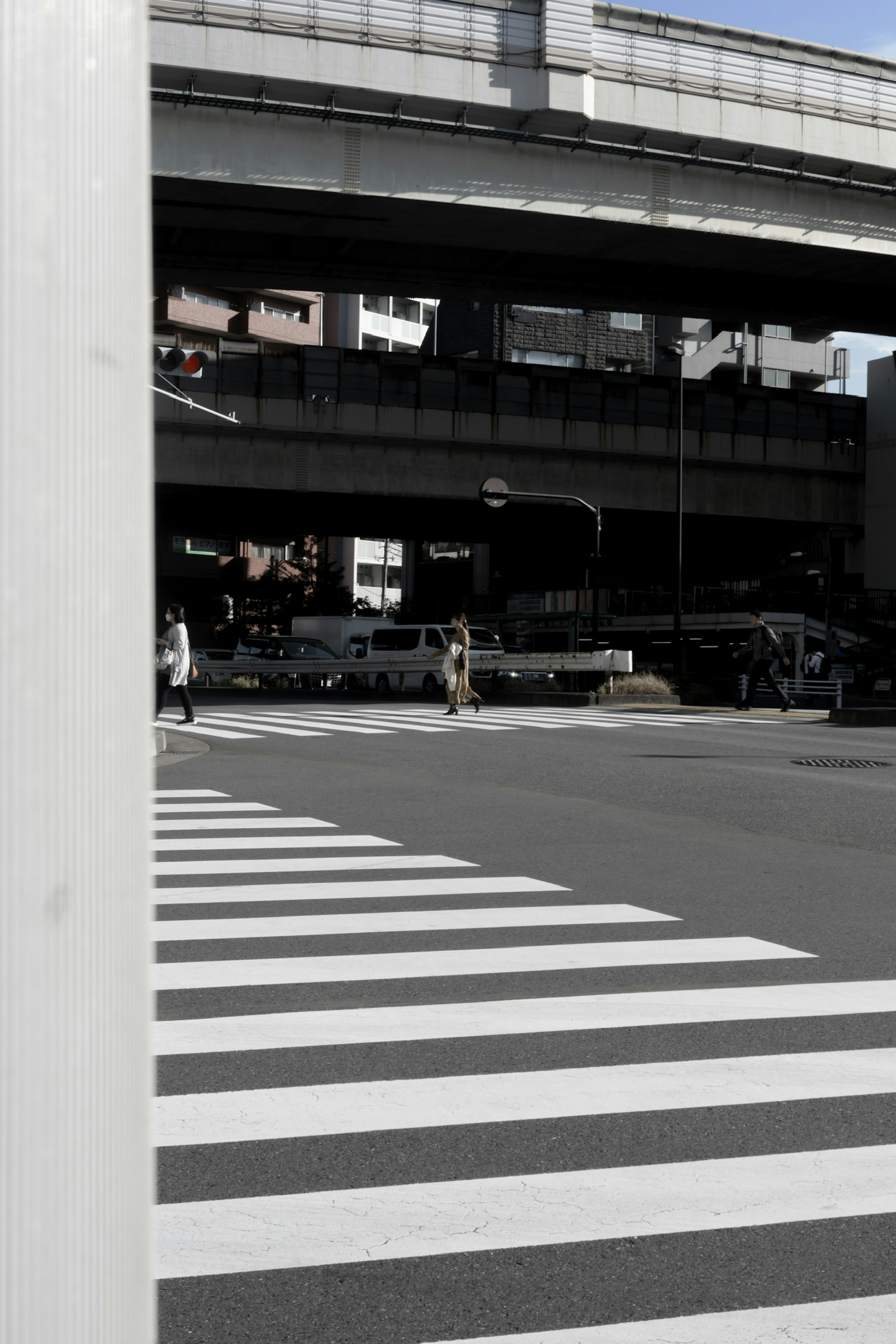 Urban scene featuring a white crosswalk and an overpass