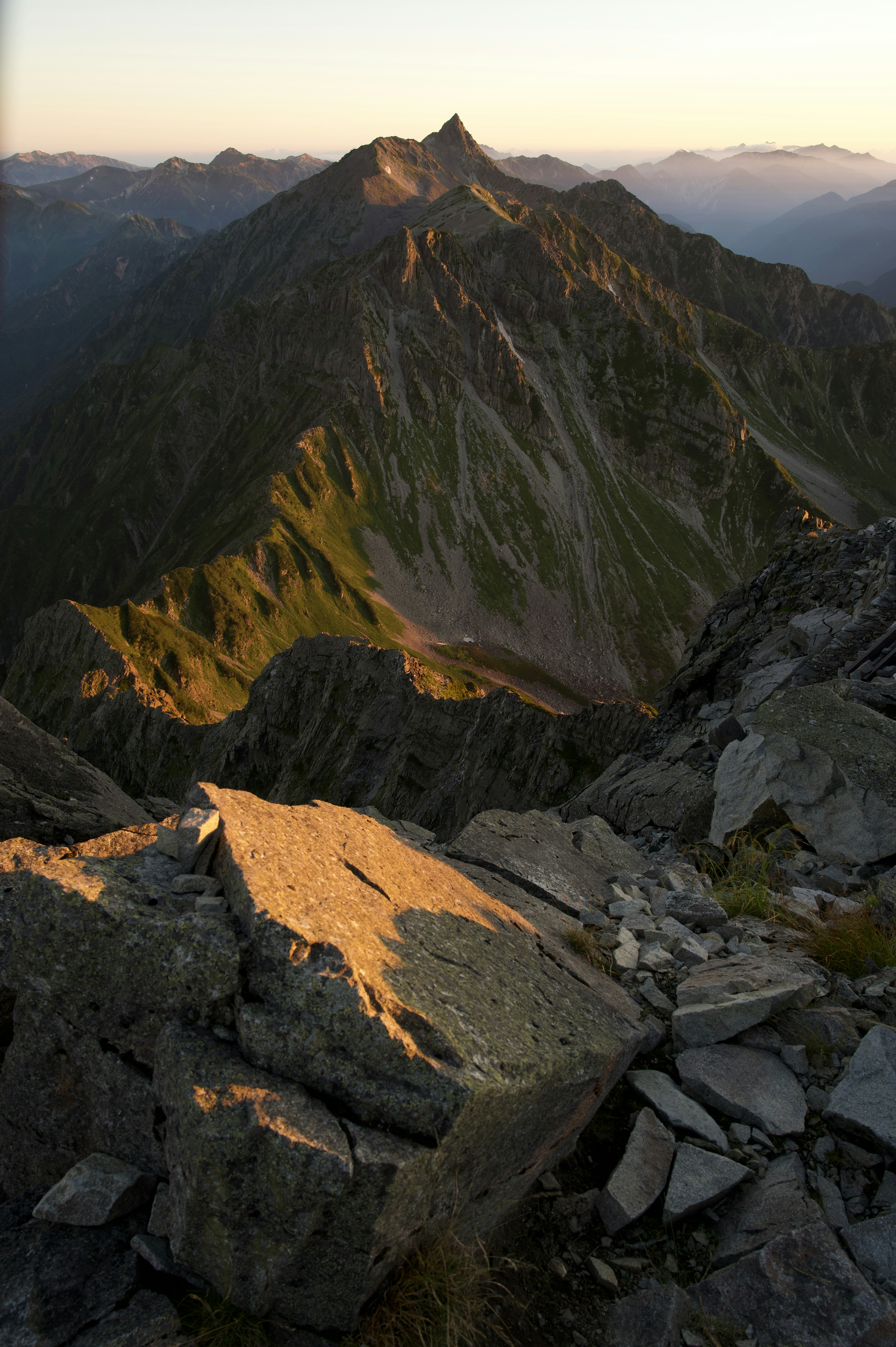 Sonnenuntergangslicht, das den Berggipfel und die steile Felsoberfläche beleuchtet