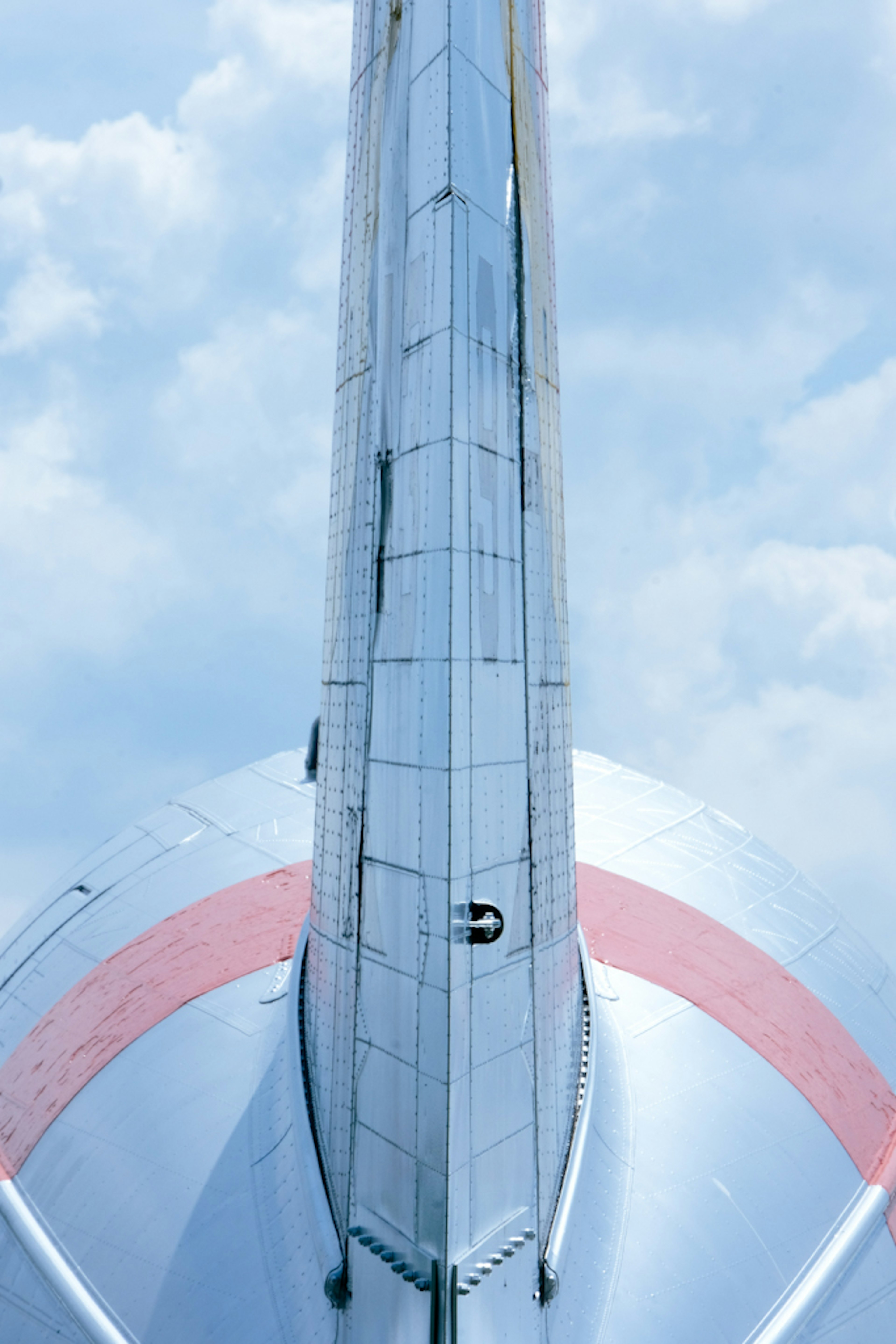 飛行機の尾翼の上からの視点青空と雲が背景