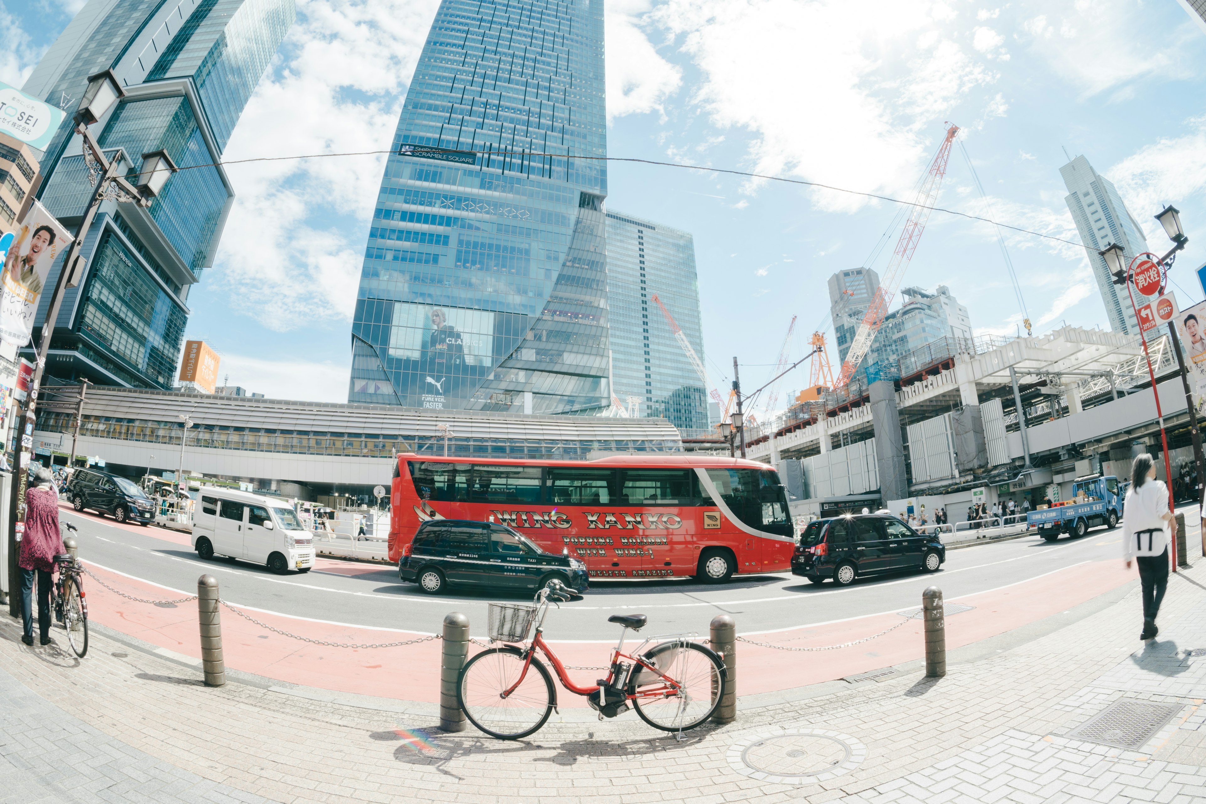 高層ビルとバスが走る街並みの風景 自転車が前景にある