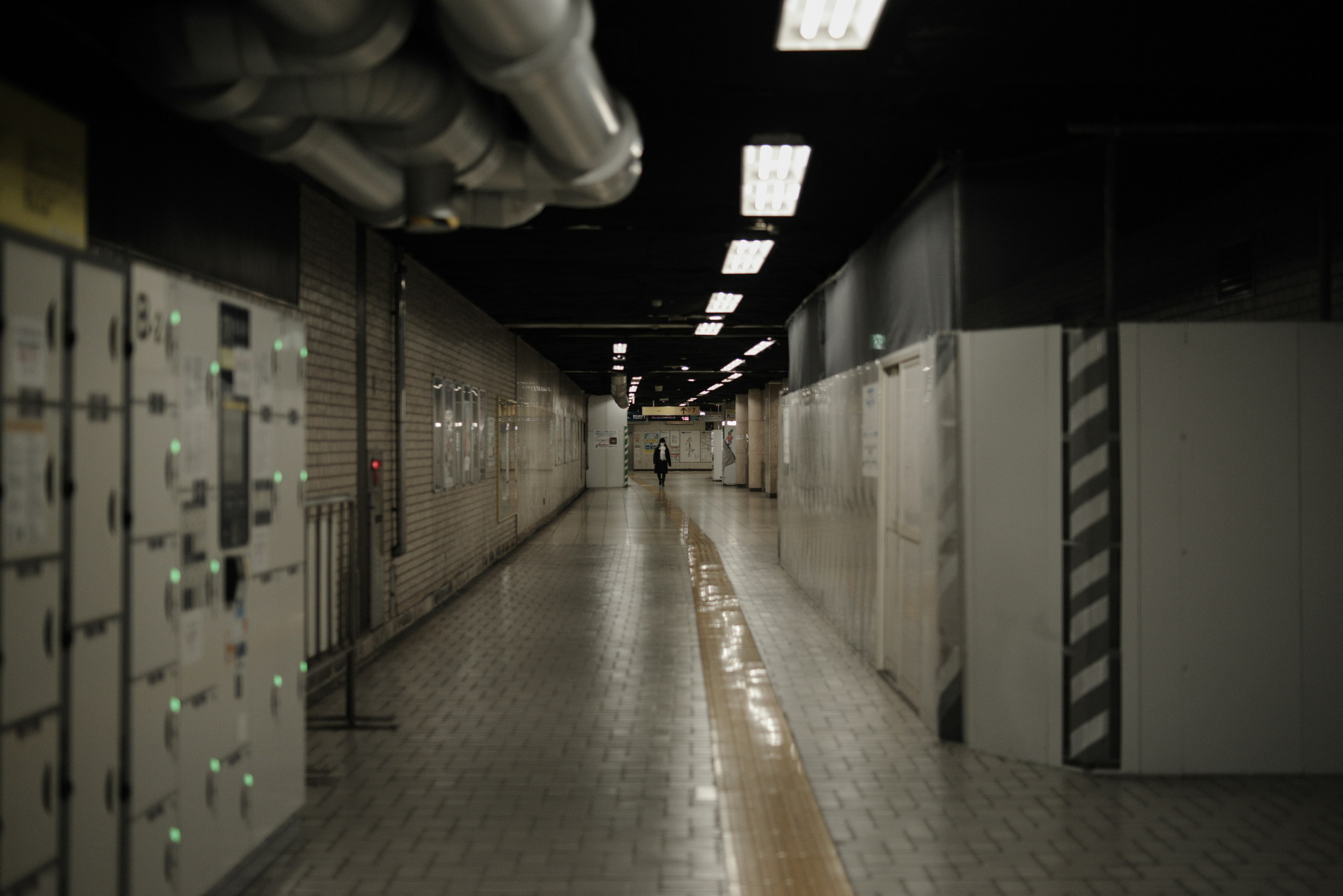 Dimly lit corridor featuring electrical panels and piping