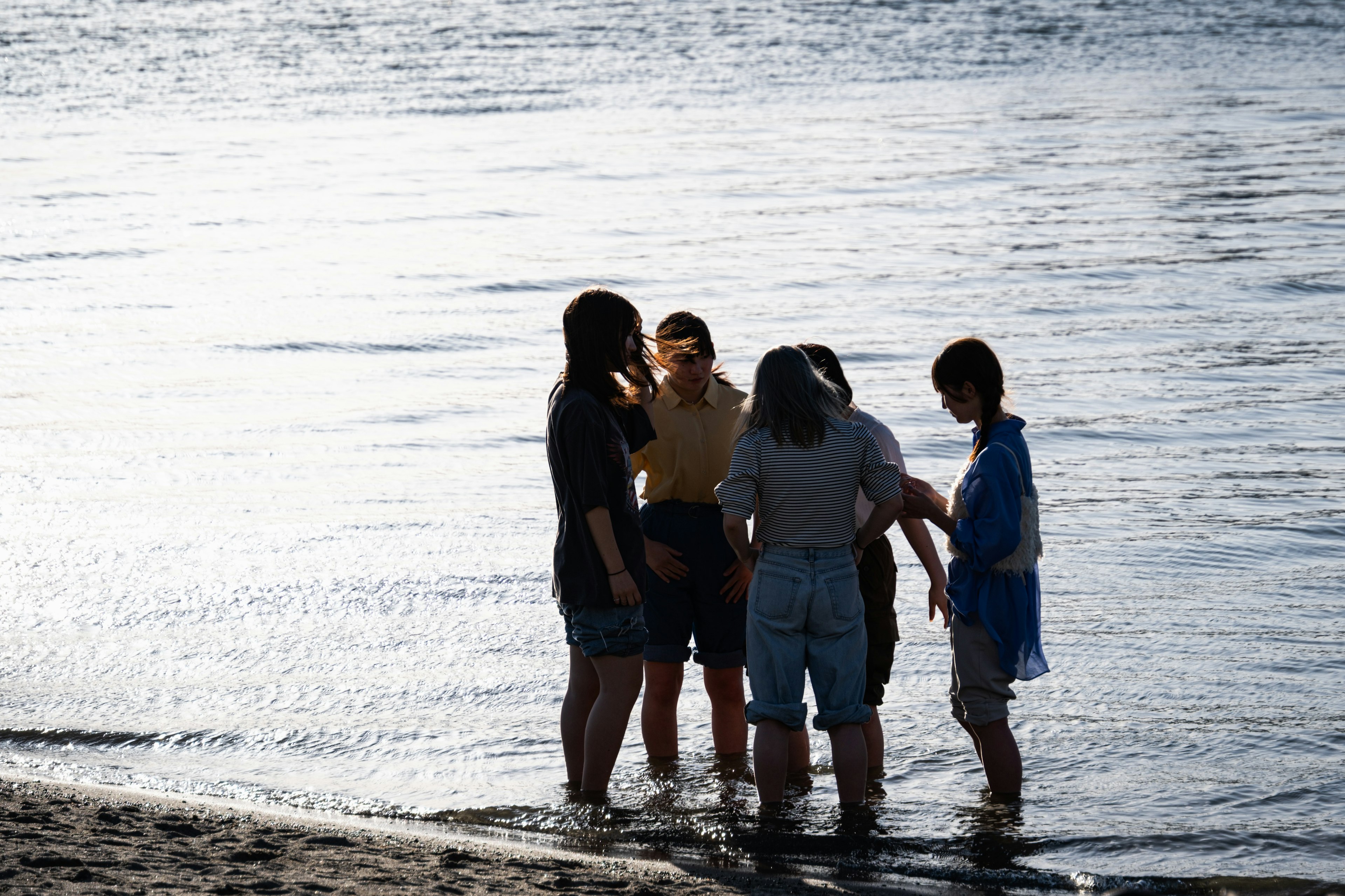 海辺で集まる若者たちのシルエット