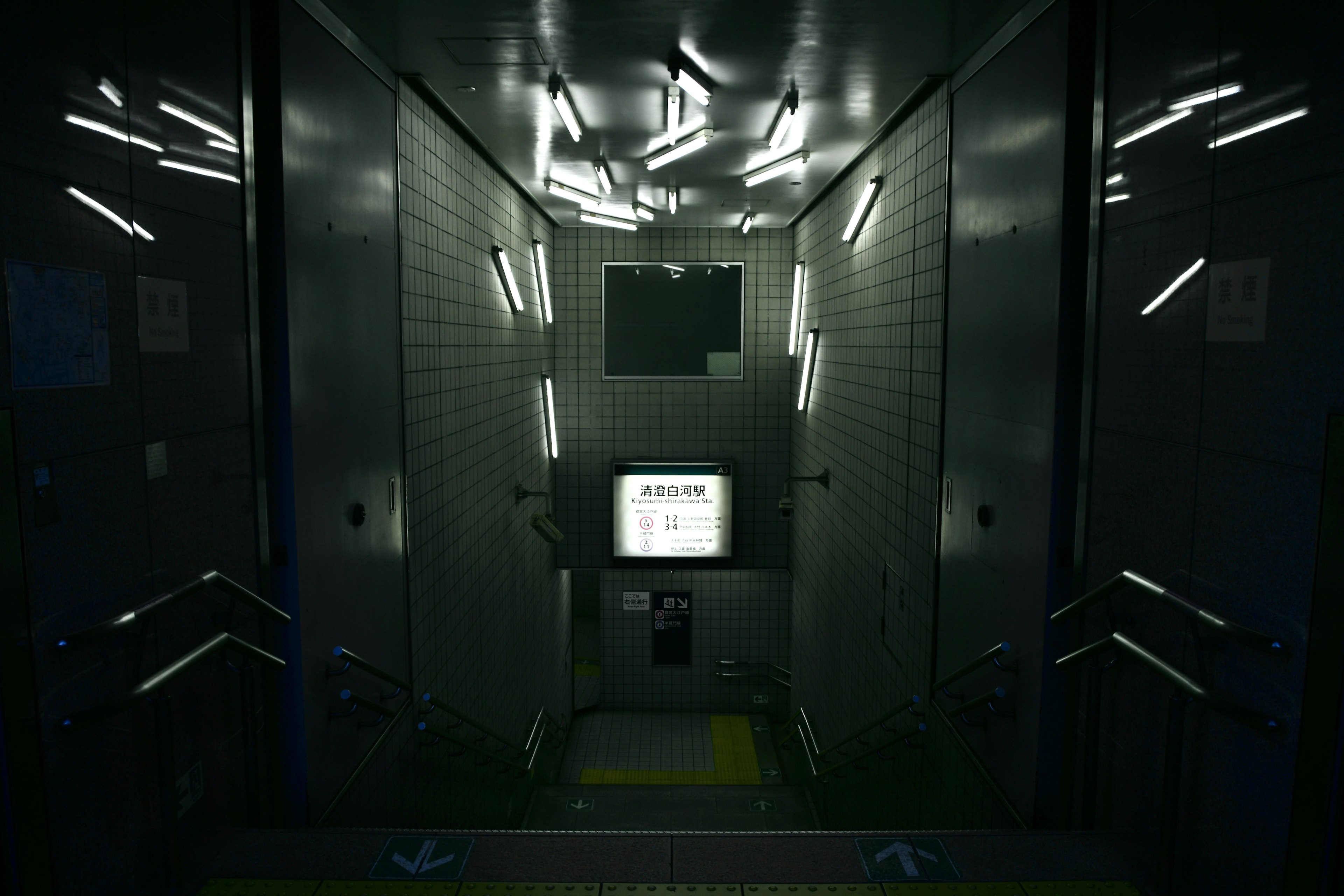 Interior of a dark elevator with bright lights and a monitor