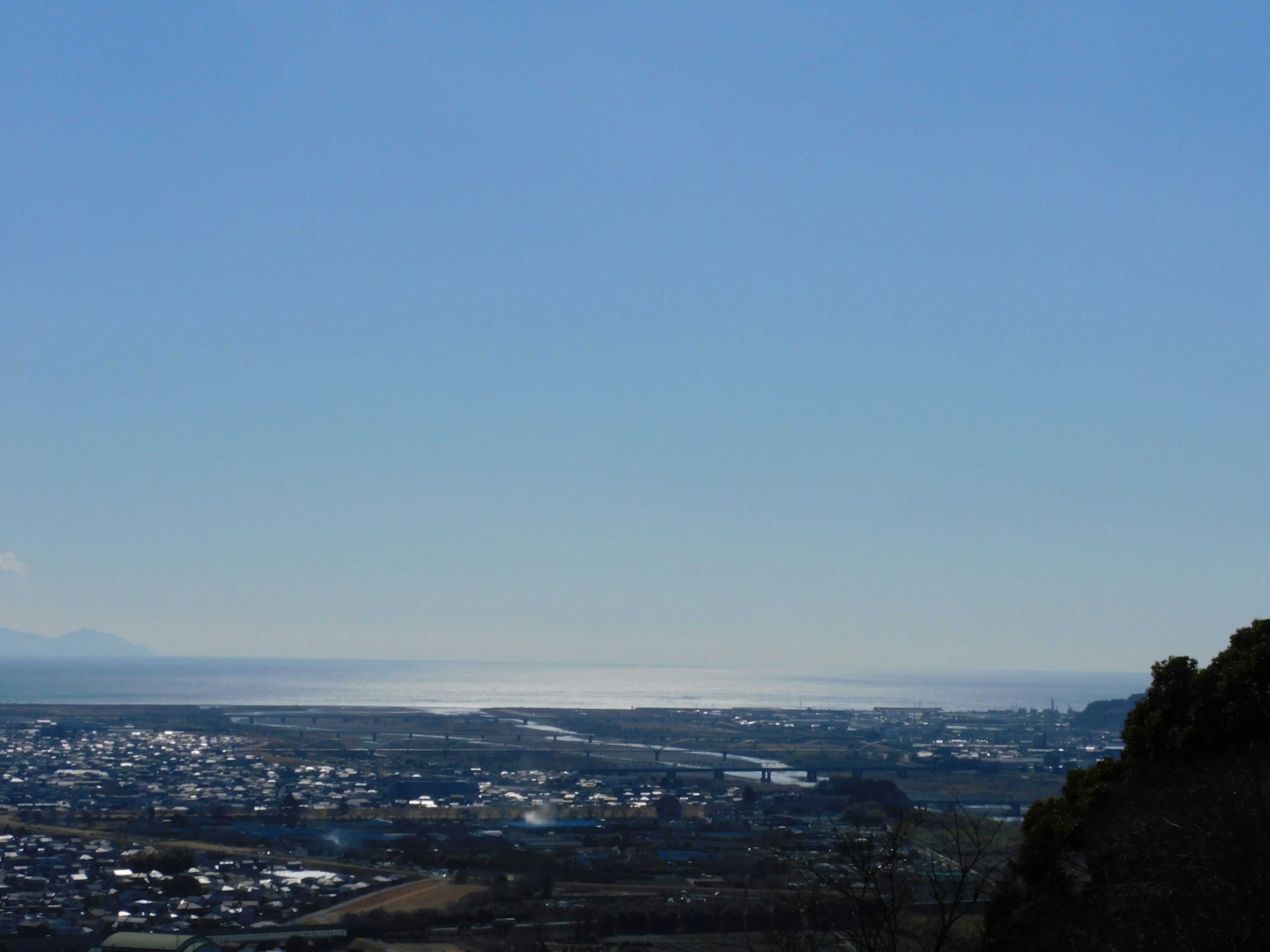 Vista panoramica di una città e dell'oceano sotto un cielo blu chiaro