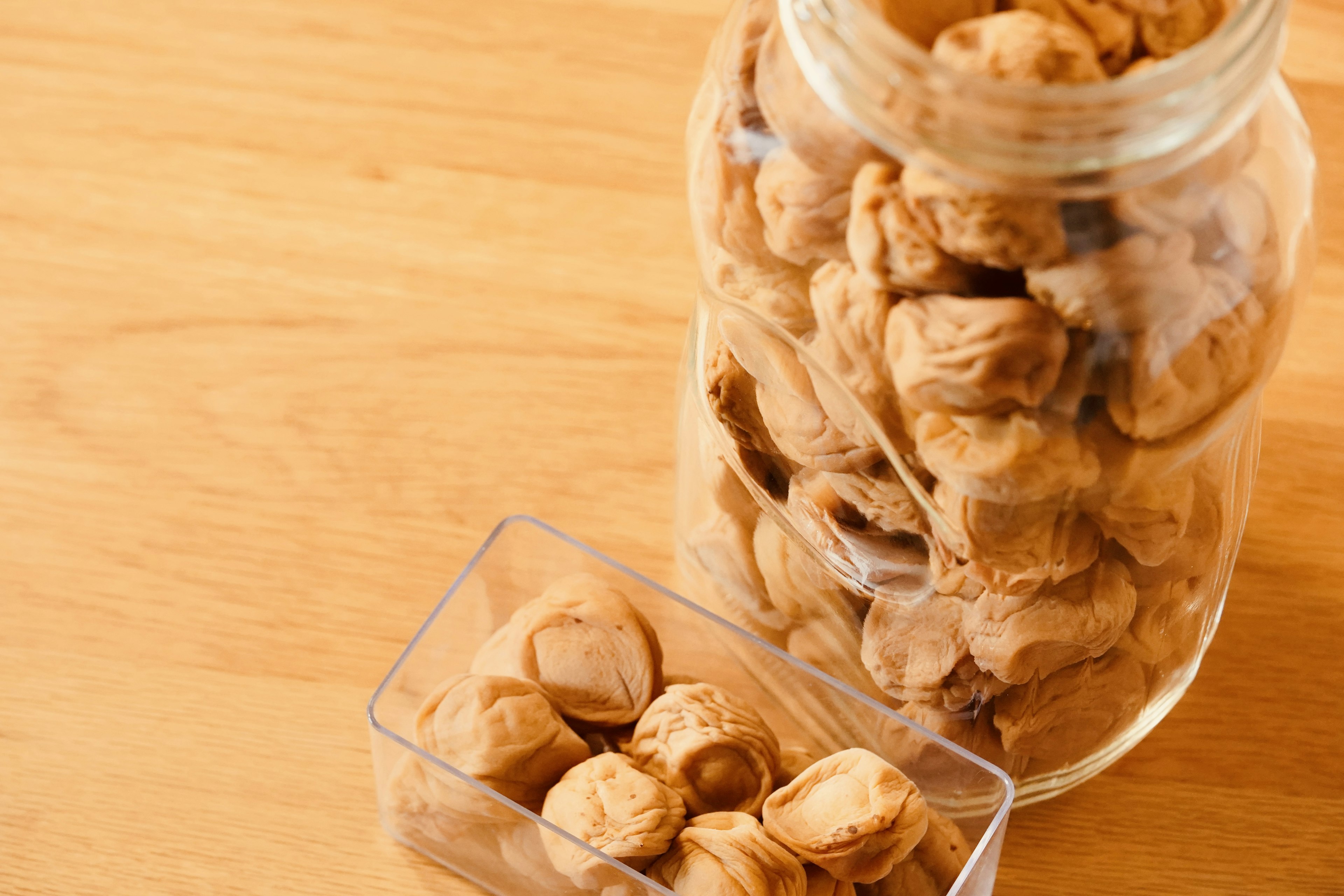 Un frasco y un recipiente llenos de nueces marrones