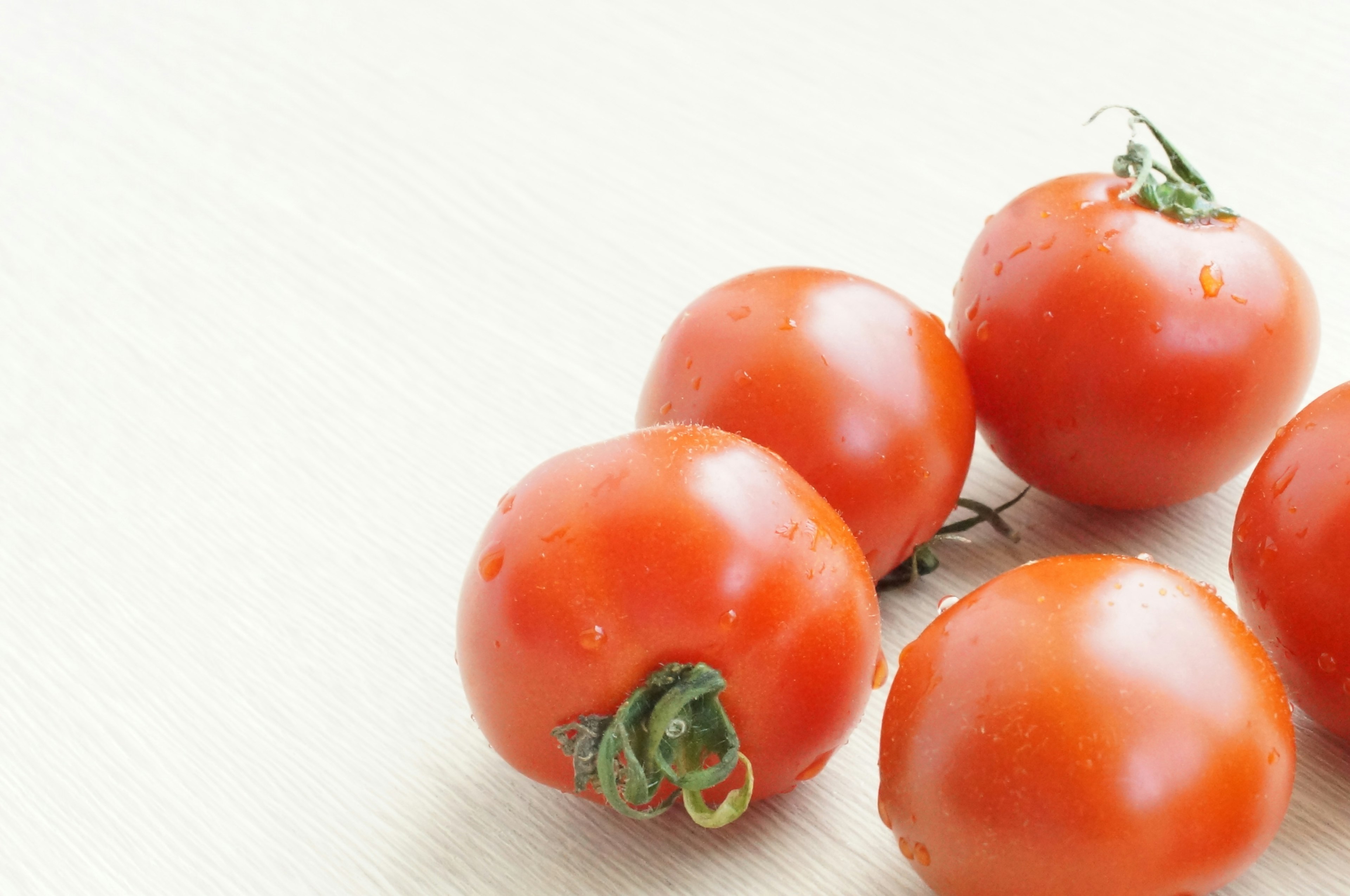 Frische Tomaten auf einer hellen Oberfläche angeordnet