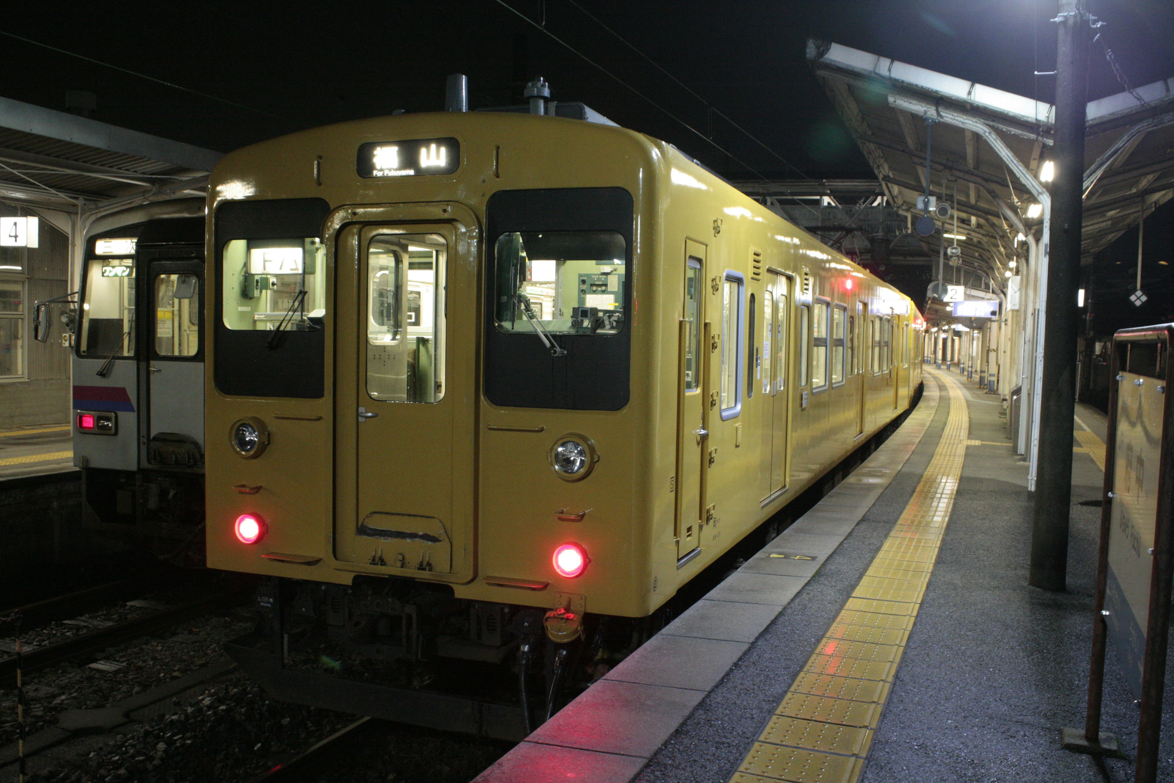 รถไฟสีเหลืองจอดที่สถานีในเวลากลางคืน