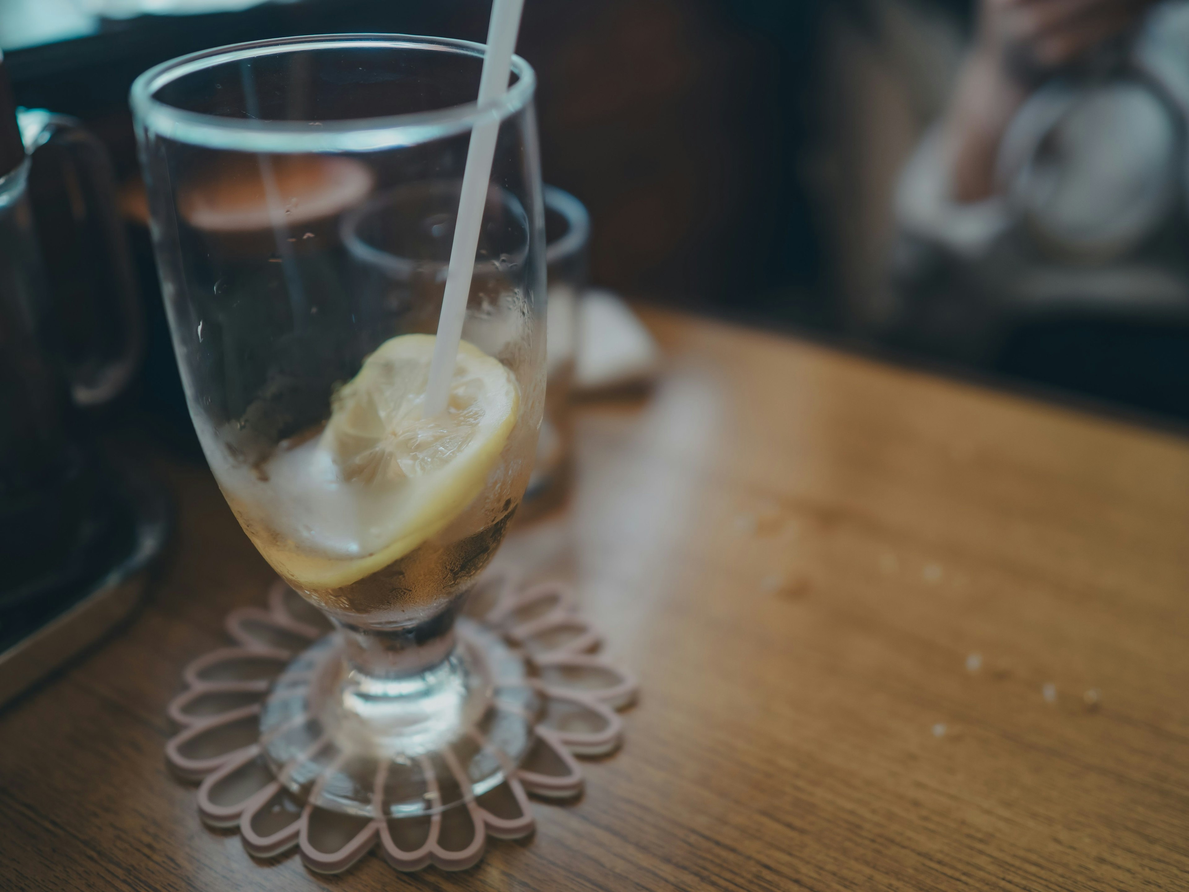 Glas mit Getränk und Zitronenscheibe auf einem Holztisch