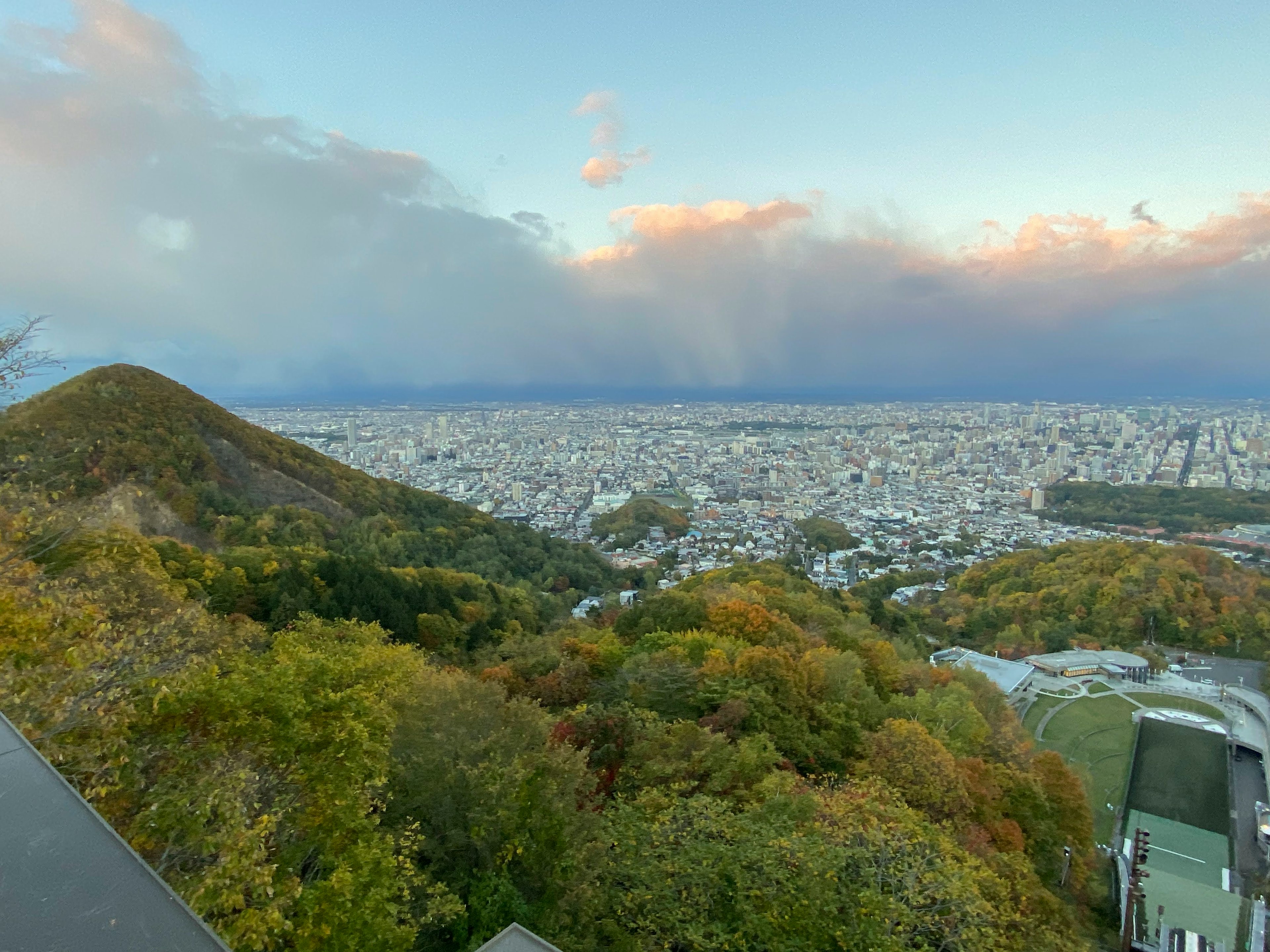 Panoramablick auf die Stadt von einem Berggipfel mit Herbstlaub