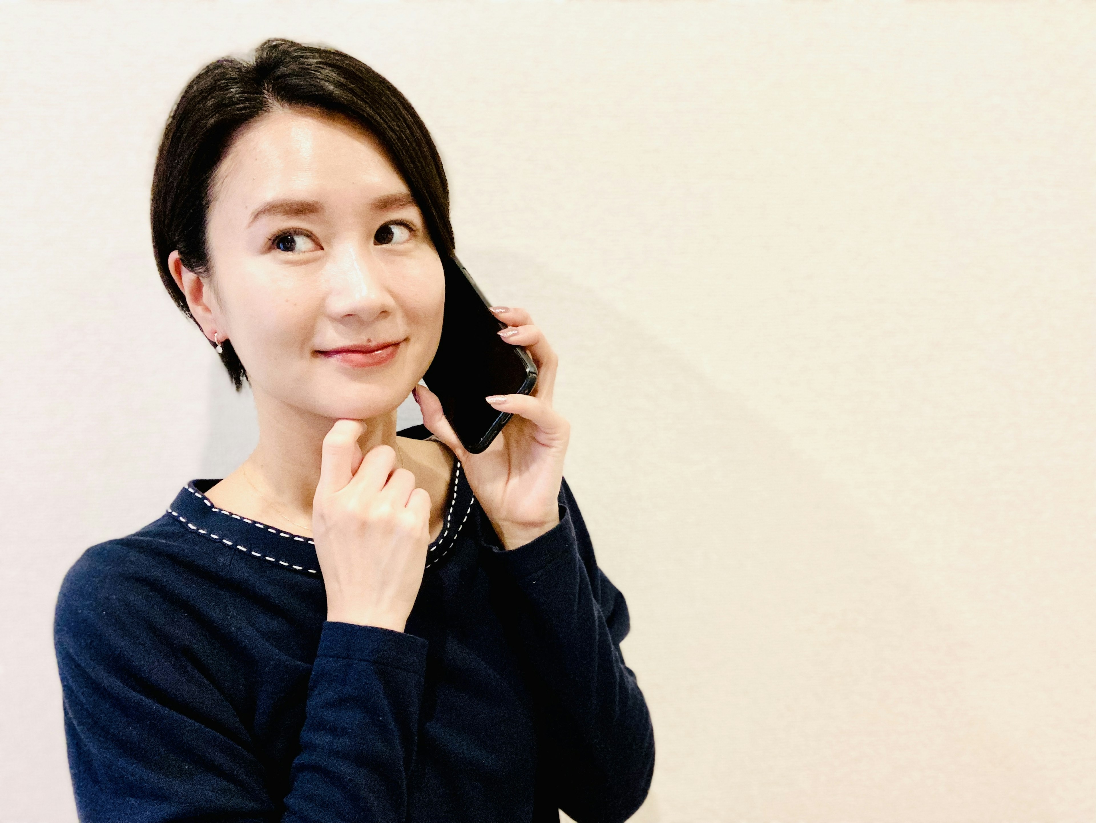 Portrait d'une femme au téléphone l'air pensif avec un sourire