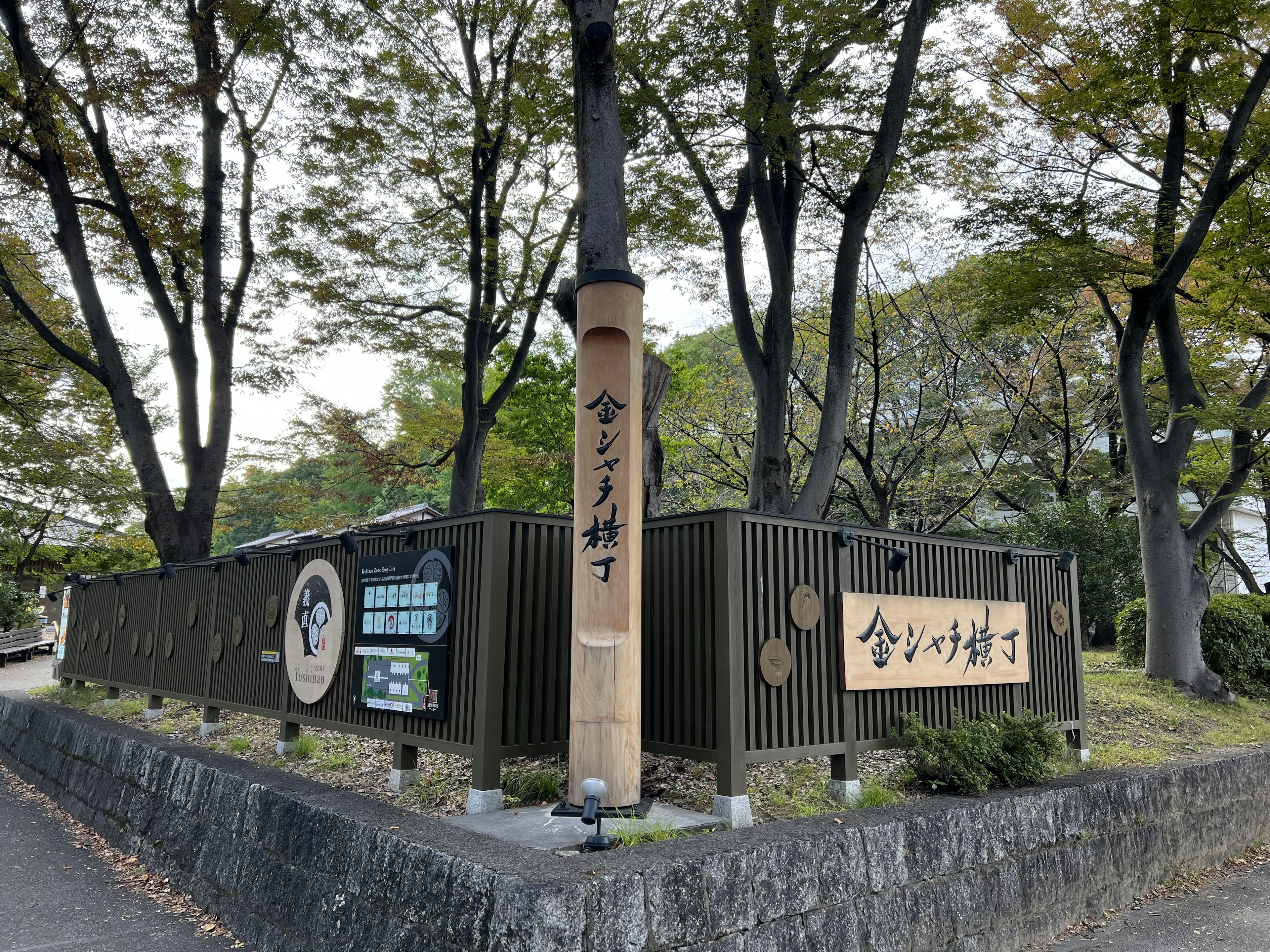 Papan kayu di pintu masuk taman dikelilingi pohon hijau