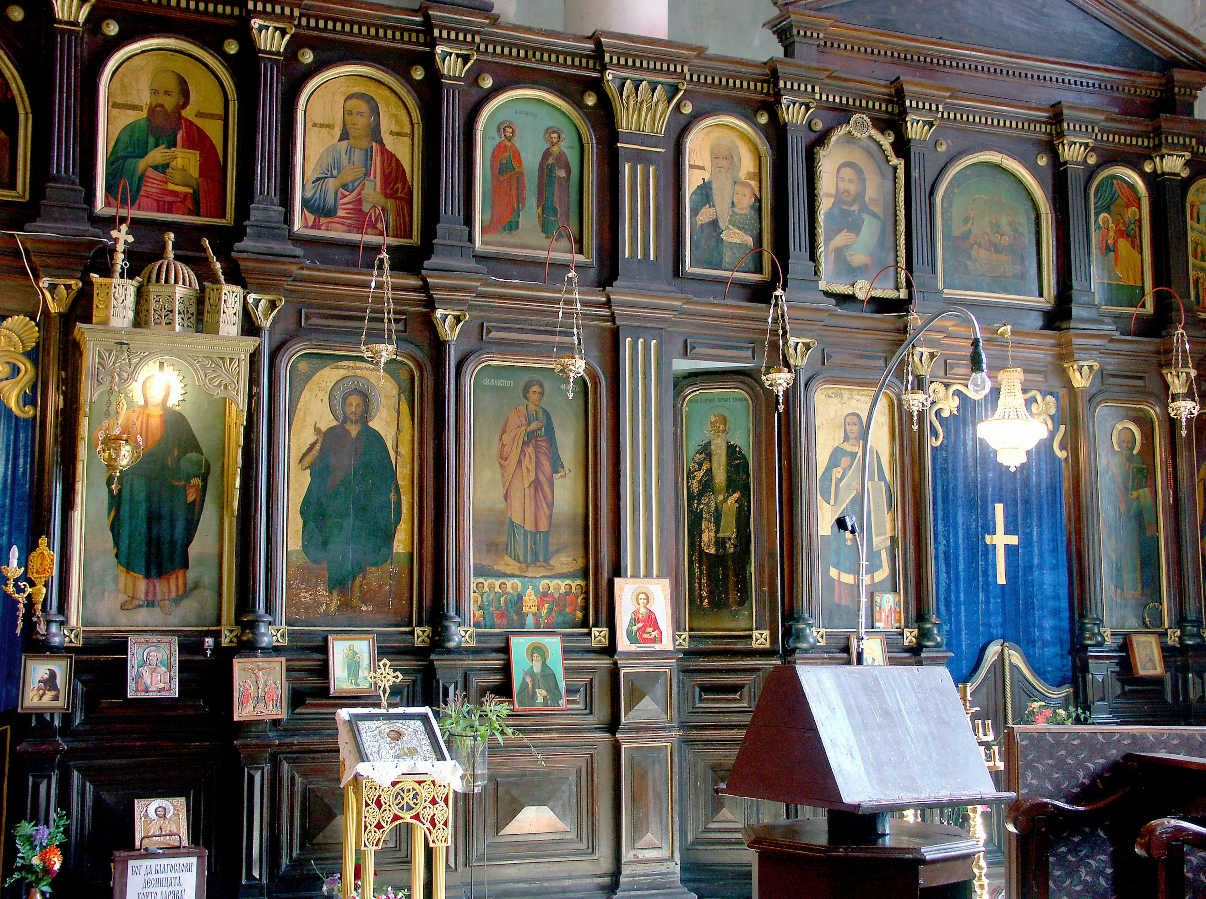 Iconos religiosos exhibidos en la pared de una iglesia con decoraciones de madera