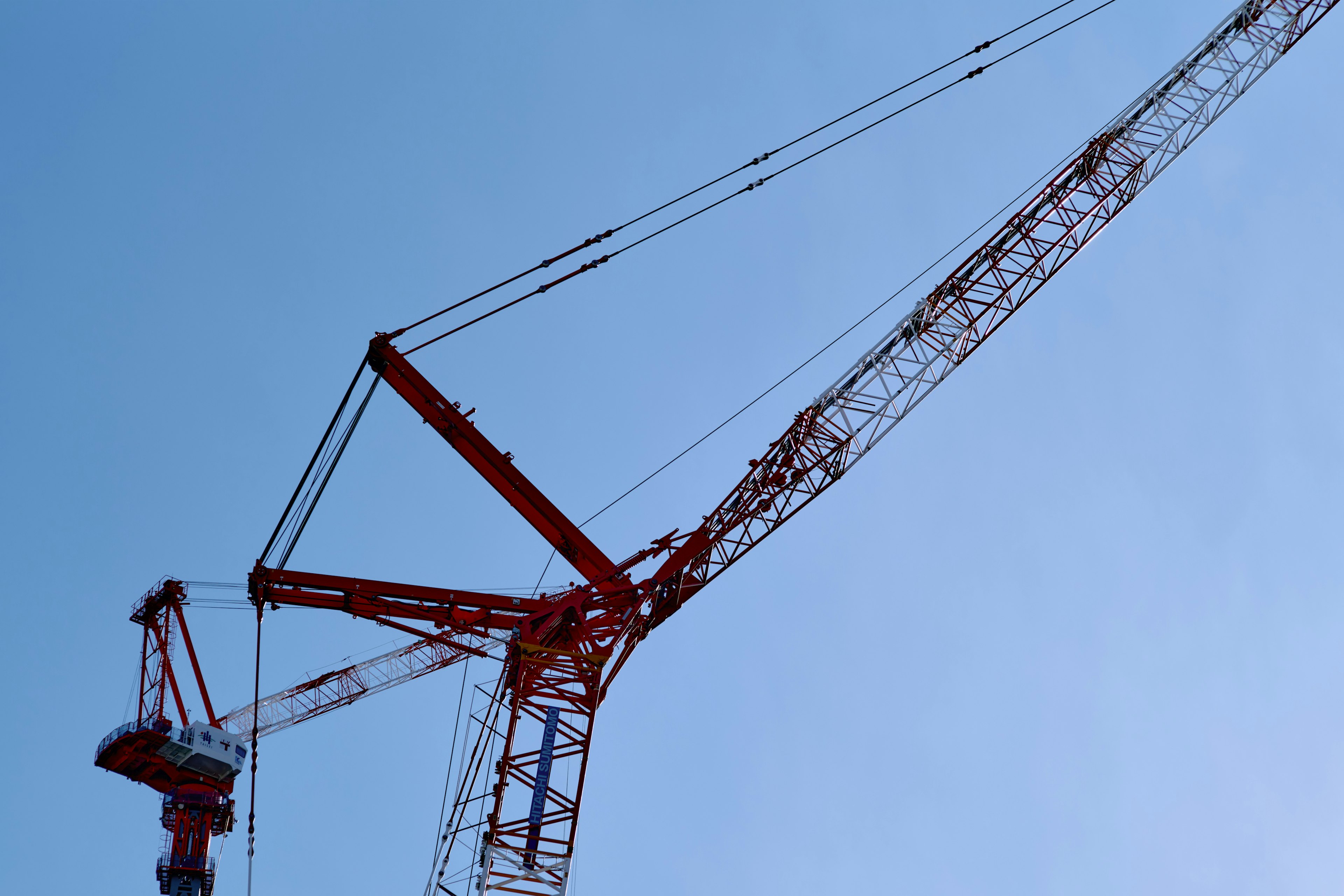 Part of a red crane against a blue sky