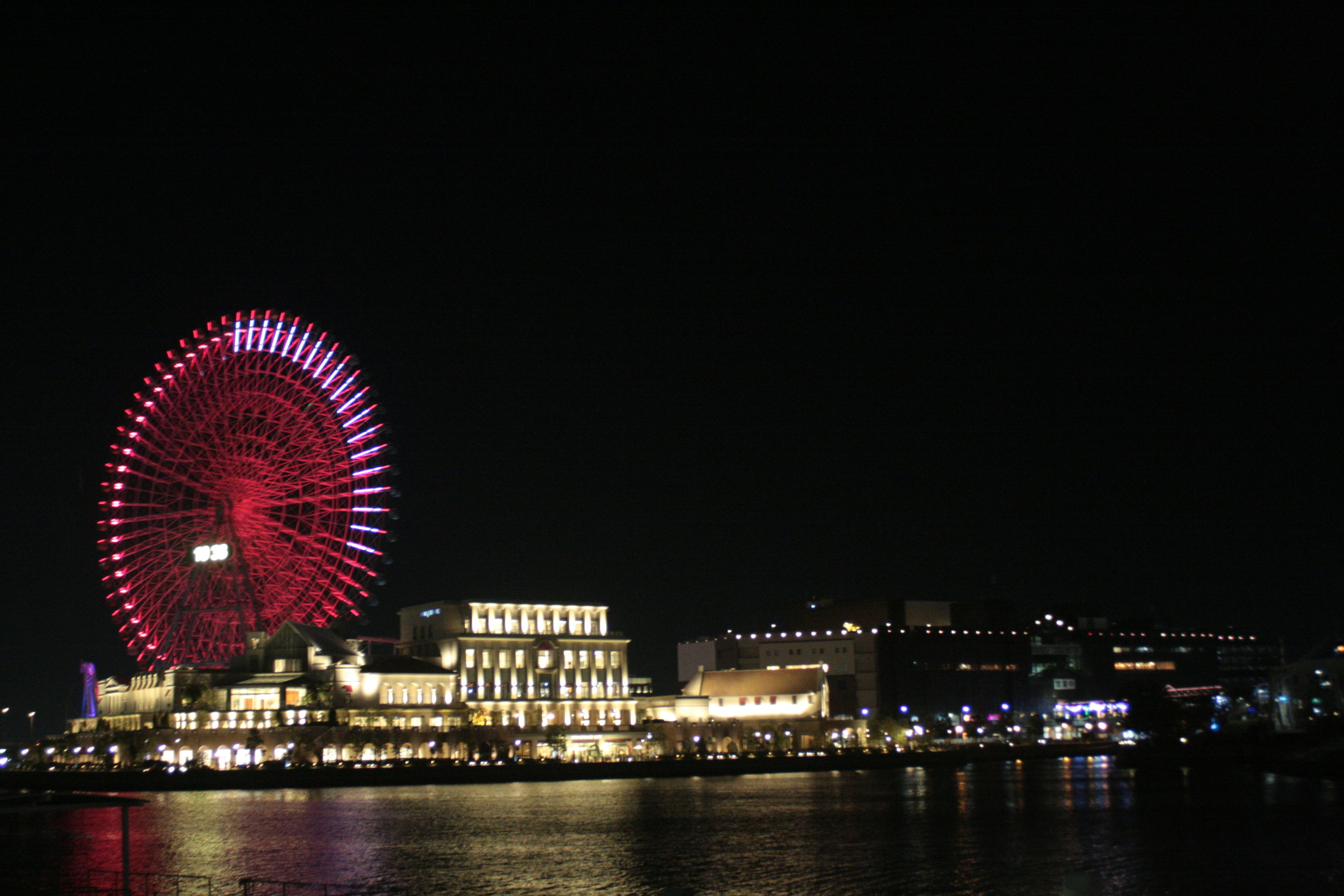 Beautiful night view featuring a ferris wheel and waterfront buildings