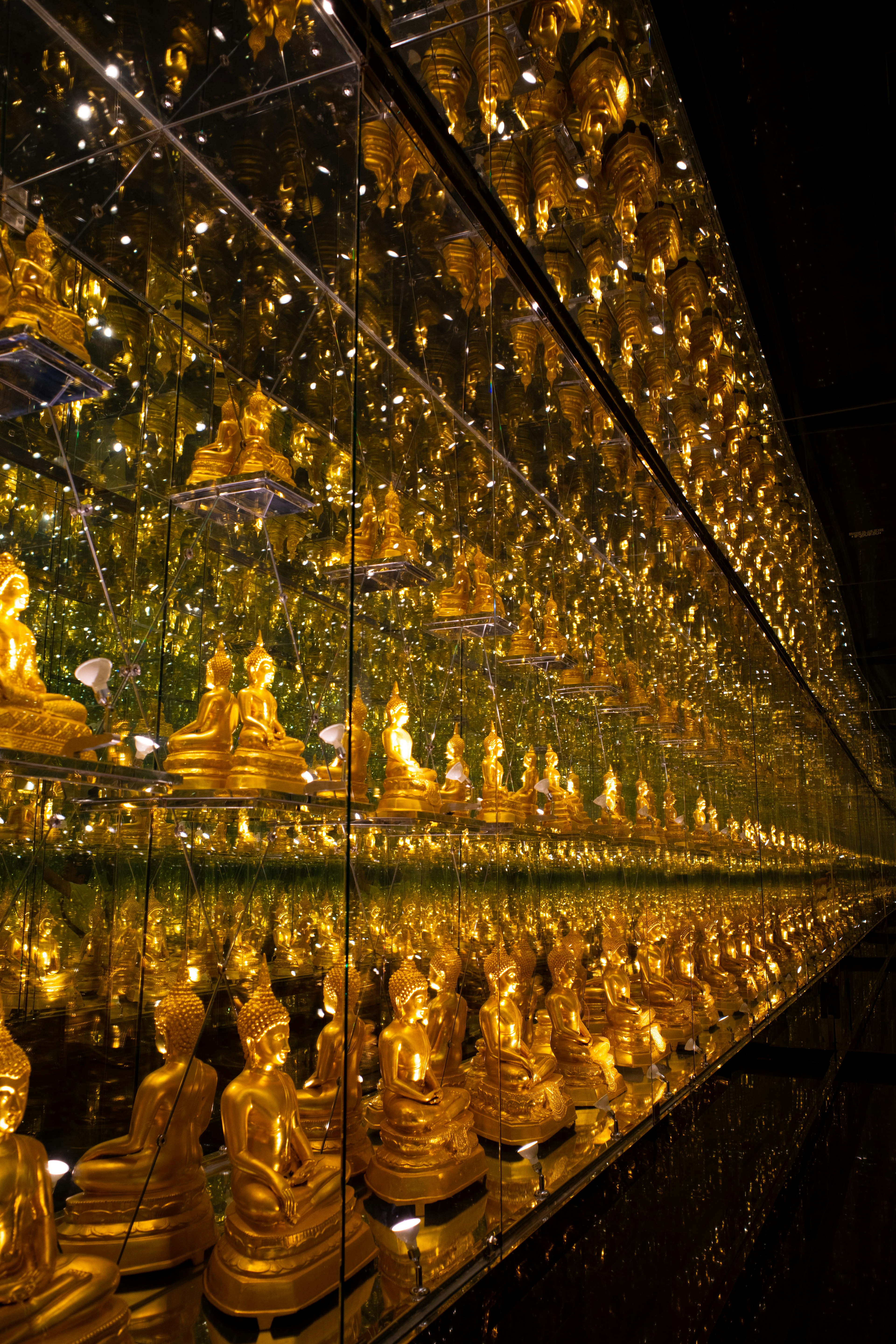 Beautiful scene of golden Buddha statues reflected in mirrors