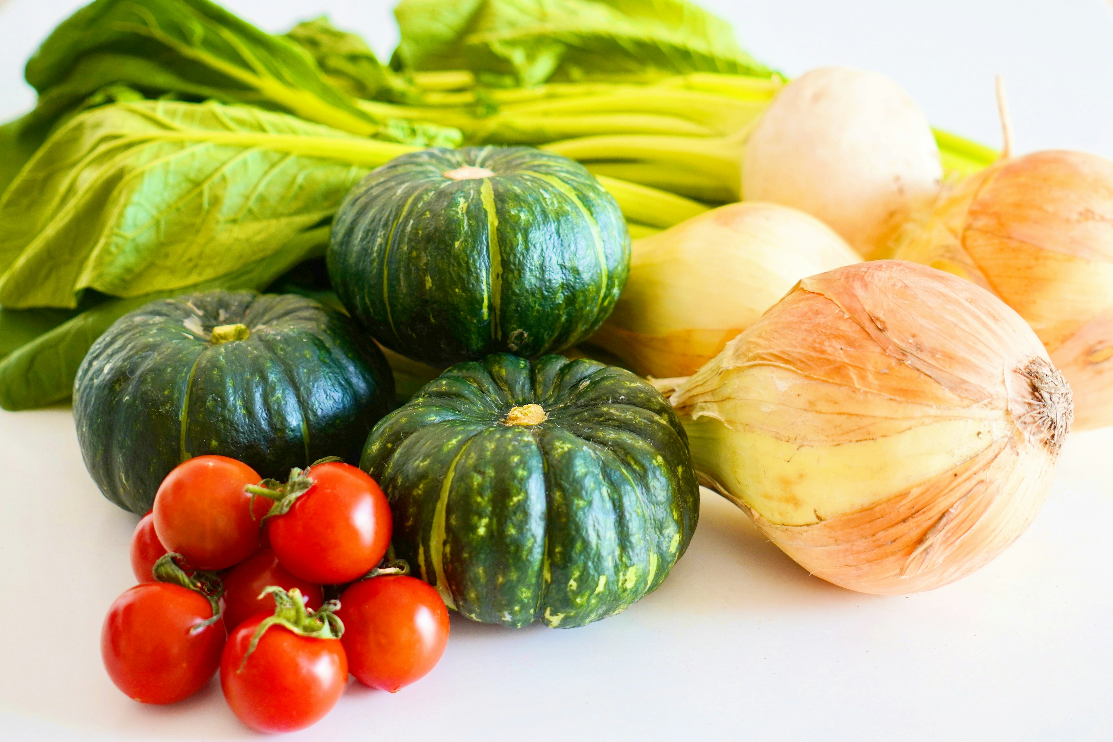 新鮮な野菜の盛り合わせに、緑色のカボチャ、赤いトマト、玉ねぎ、セロリが含まれている