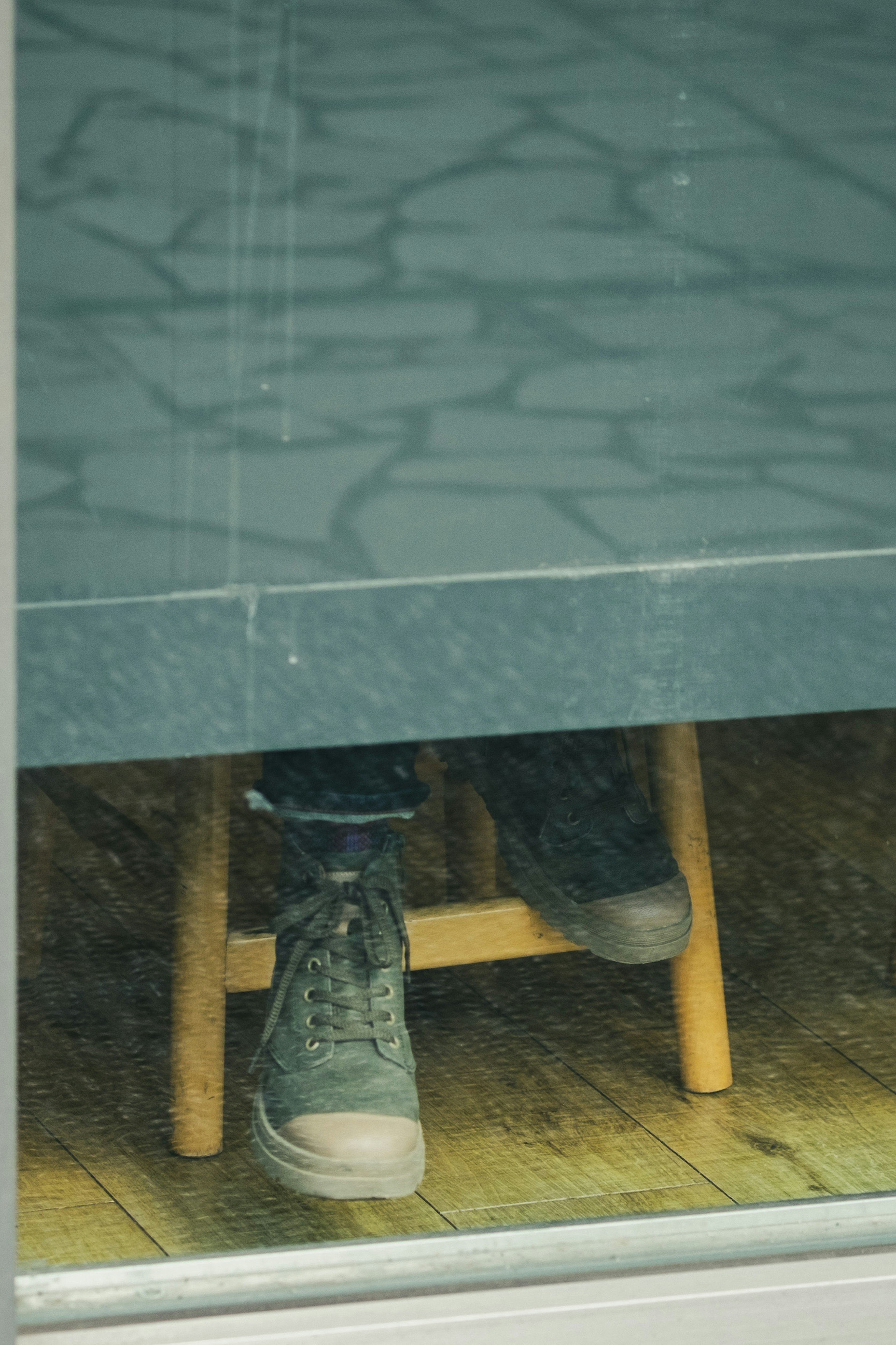 Visible shoes and part of a stool through a window