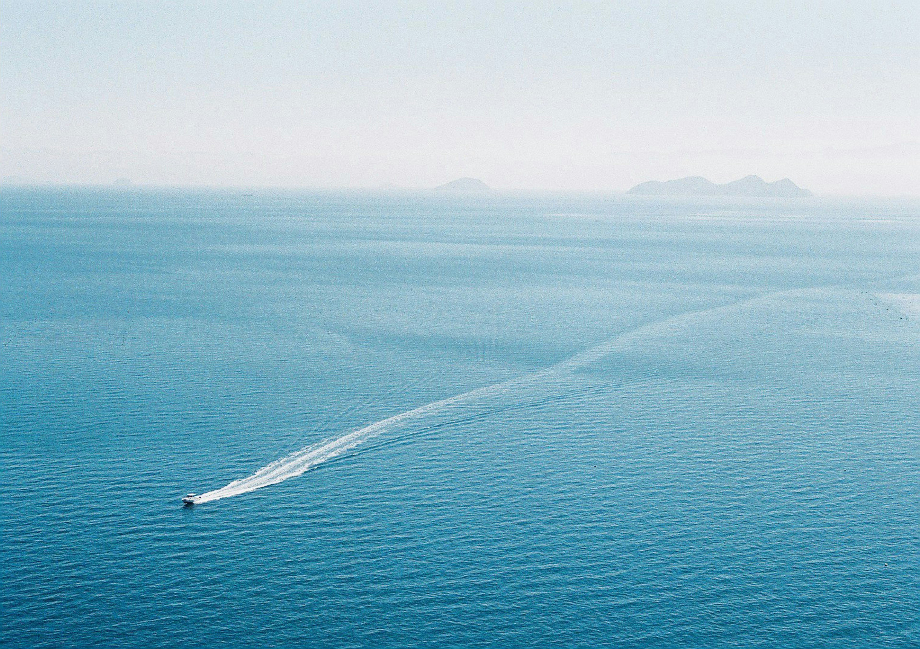 青い海を航行するボートの上空からの景色