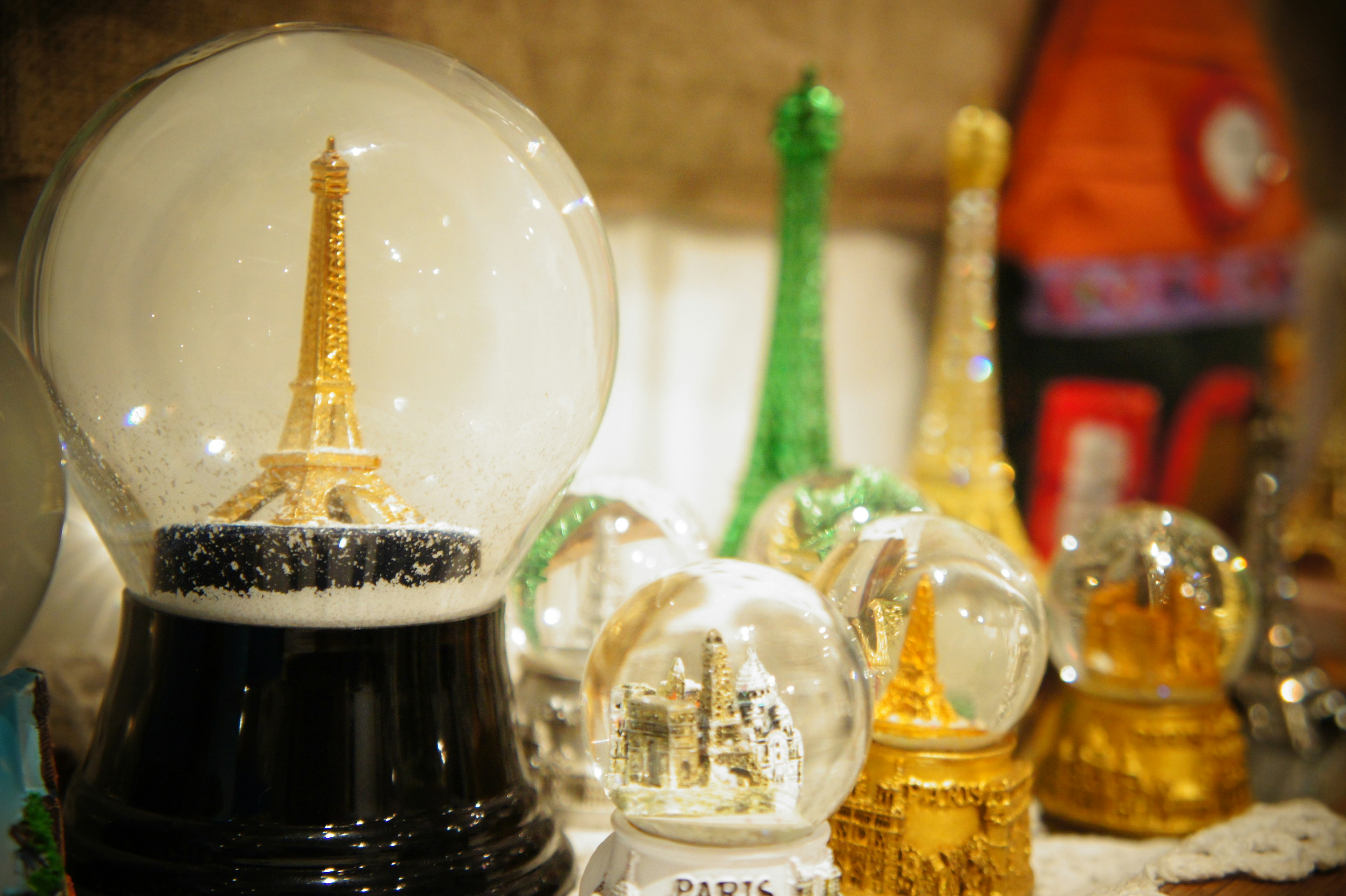 A collection of colorful snow globes featuring the Eiffel Tower