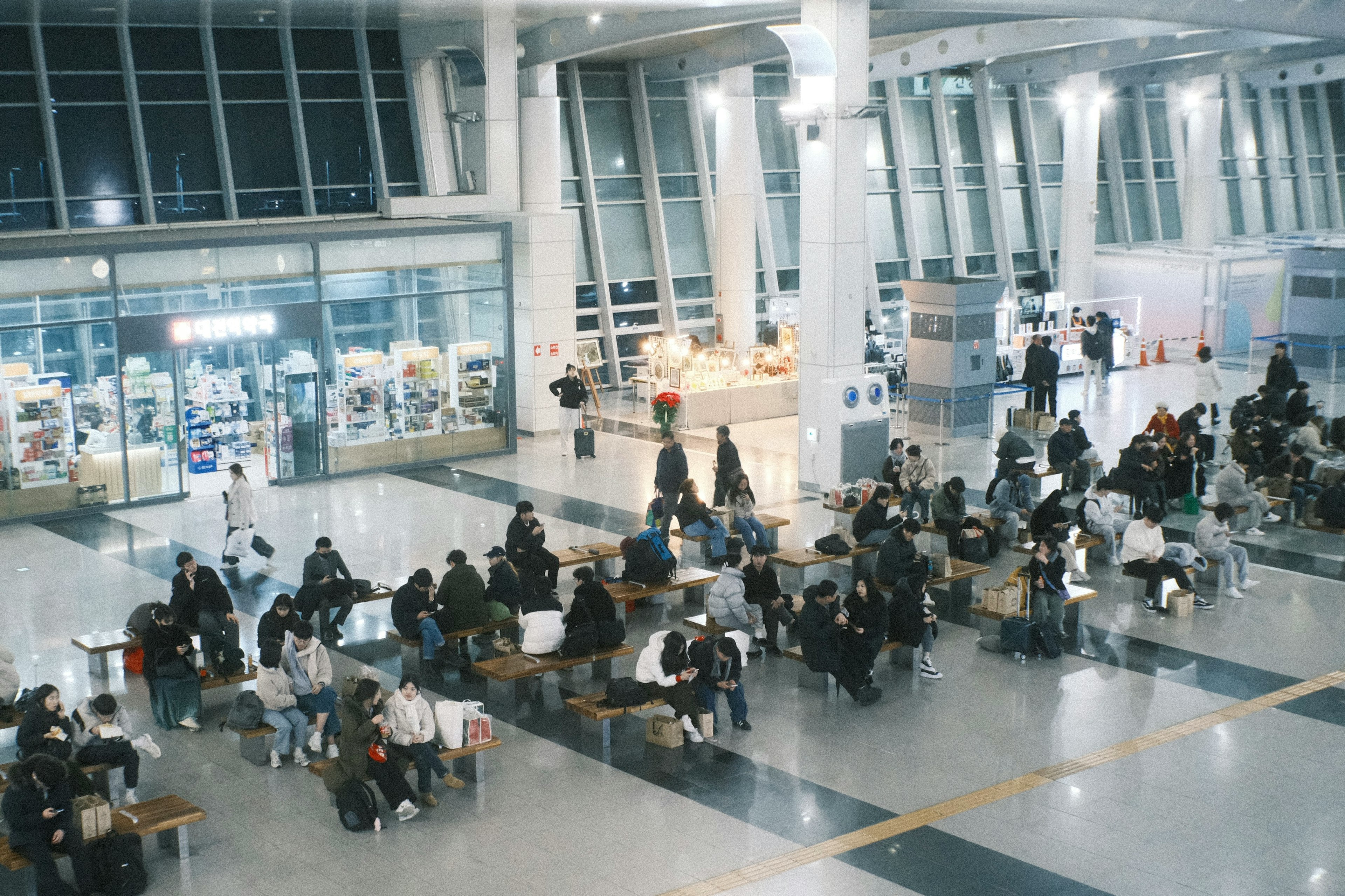 Geräumiger Wartebereich im Flughafen mit vielen Menschen an Tischen