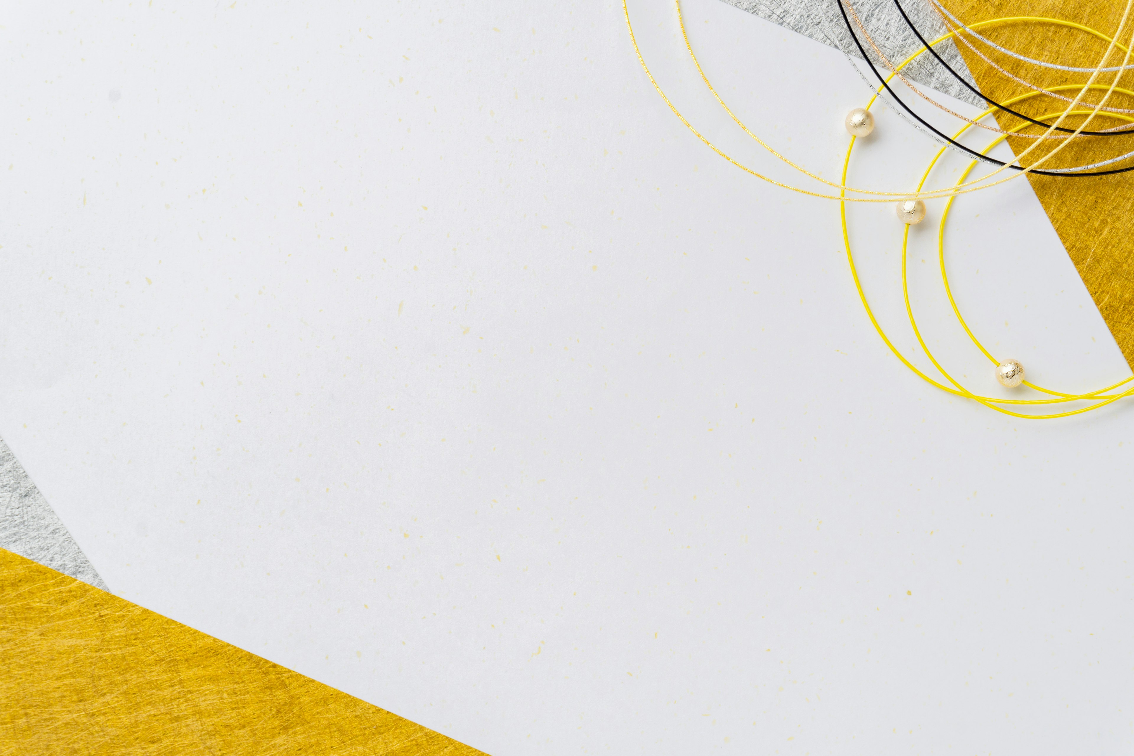 An image featuring a white background with yellow fabric and metallic wire arranged artistically