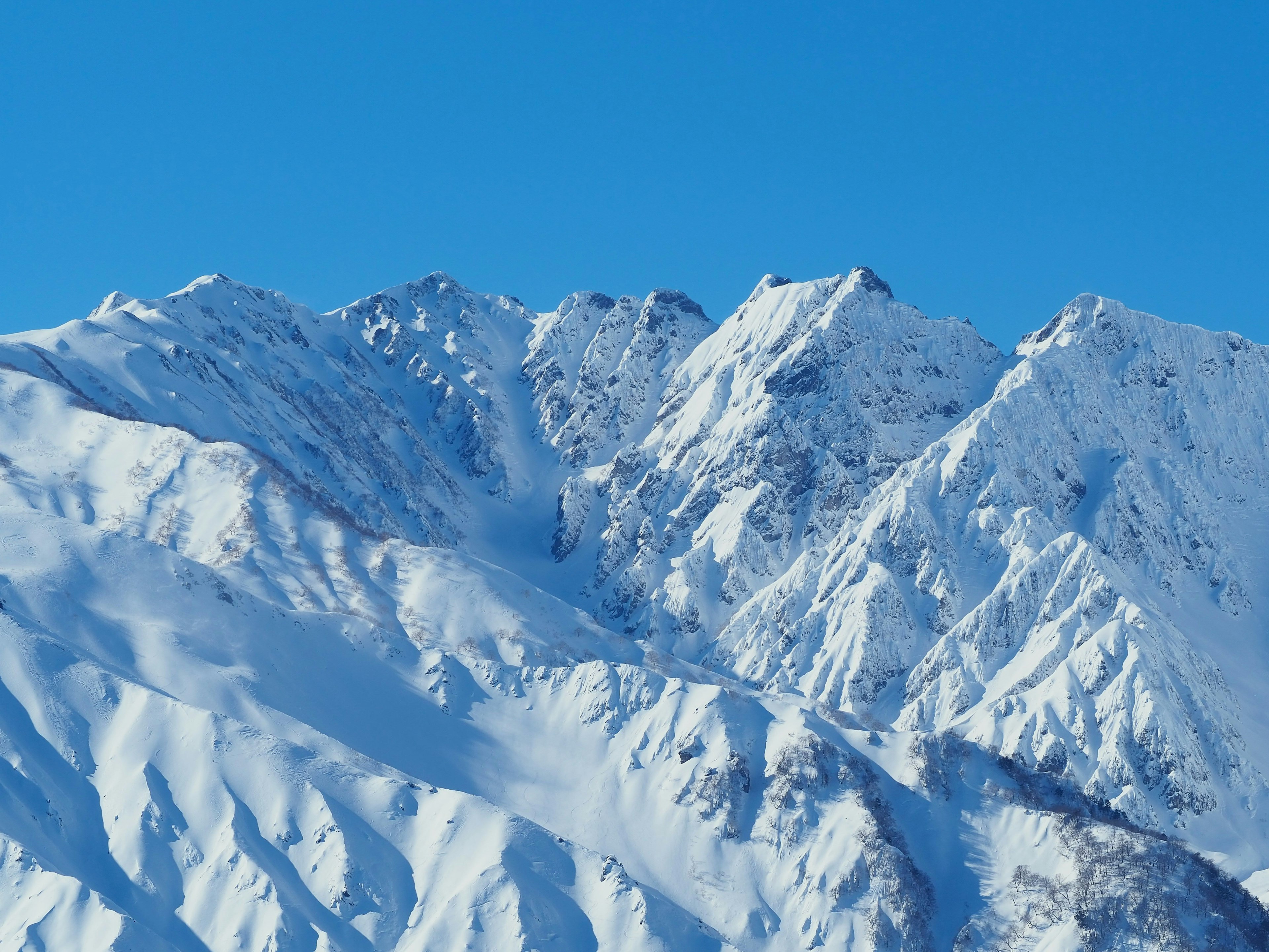 Snow-covered mountains with a clear blue sky