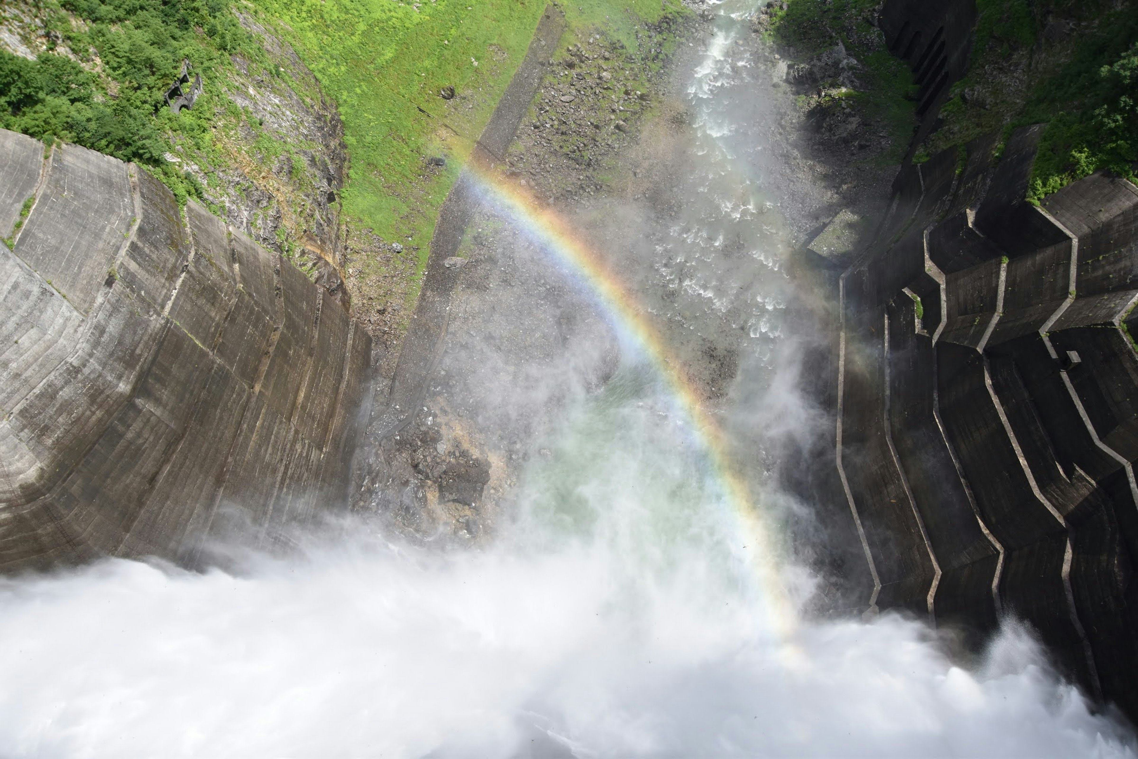 View from above a waterfall with a rainbow in the mist