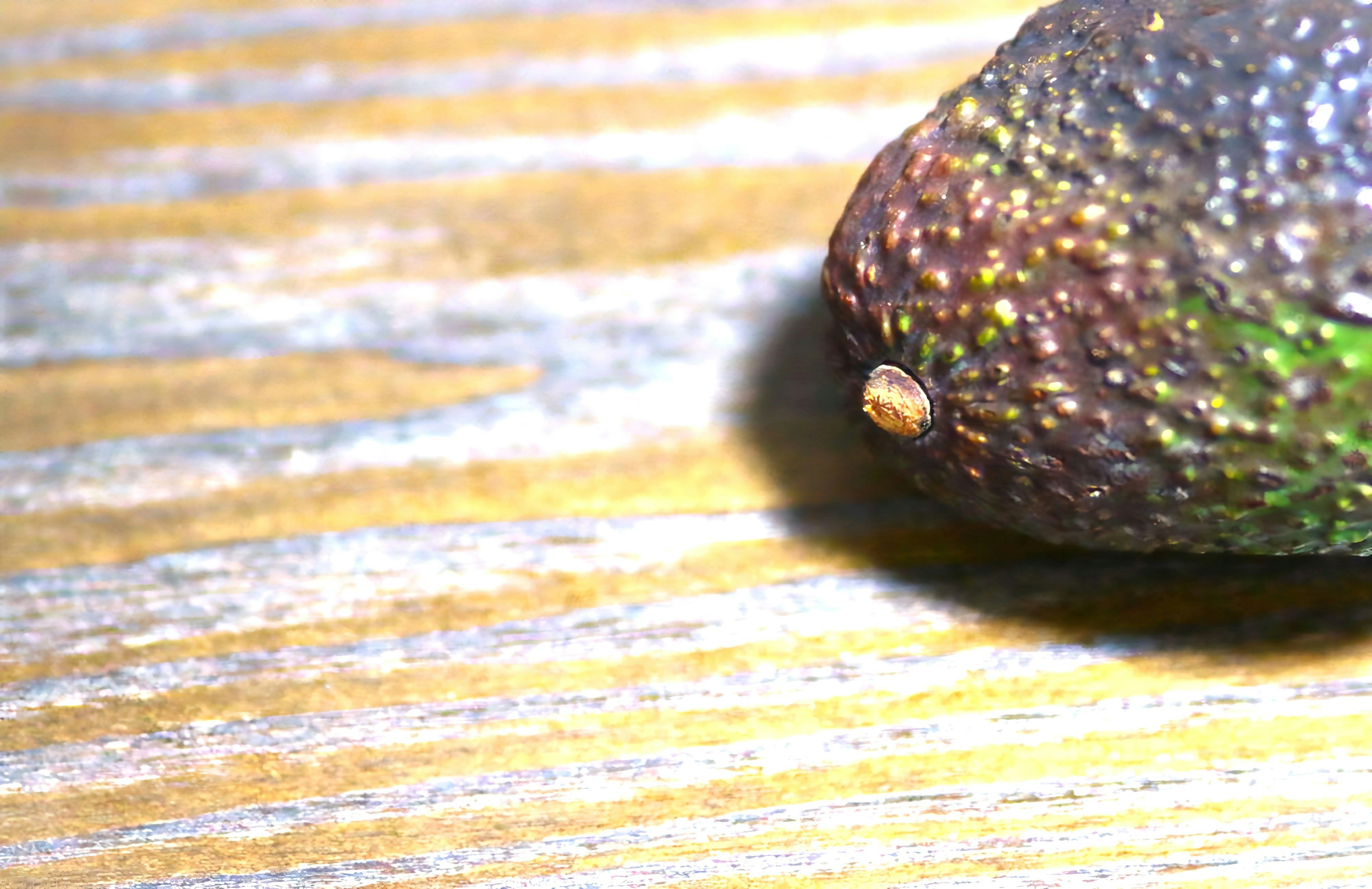 Acercamiento de un aguacate sobre una mesa de madera