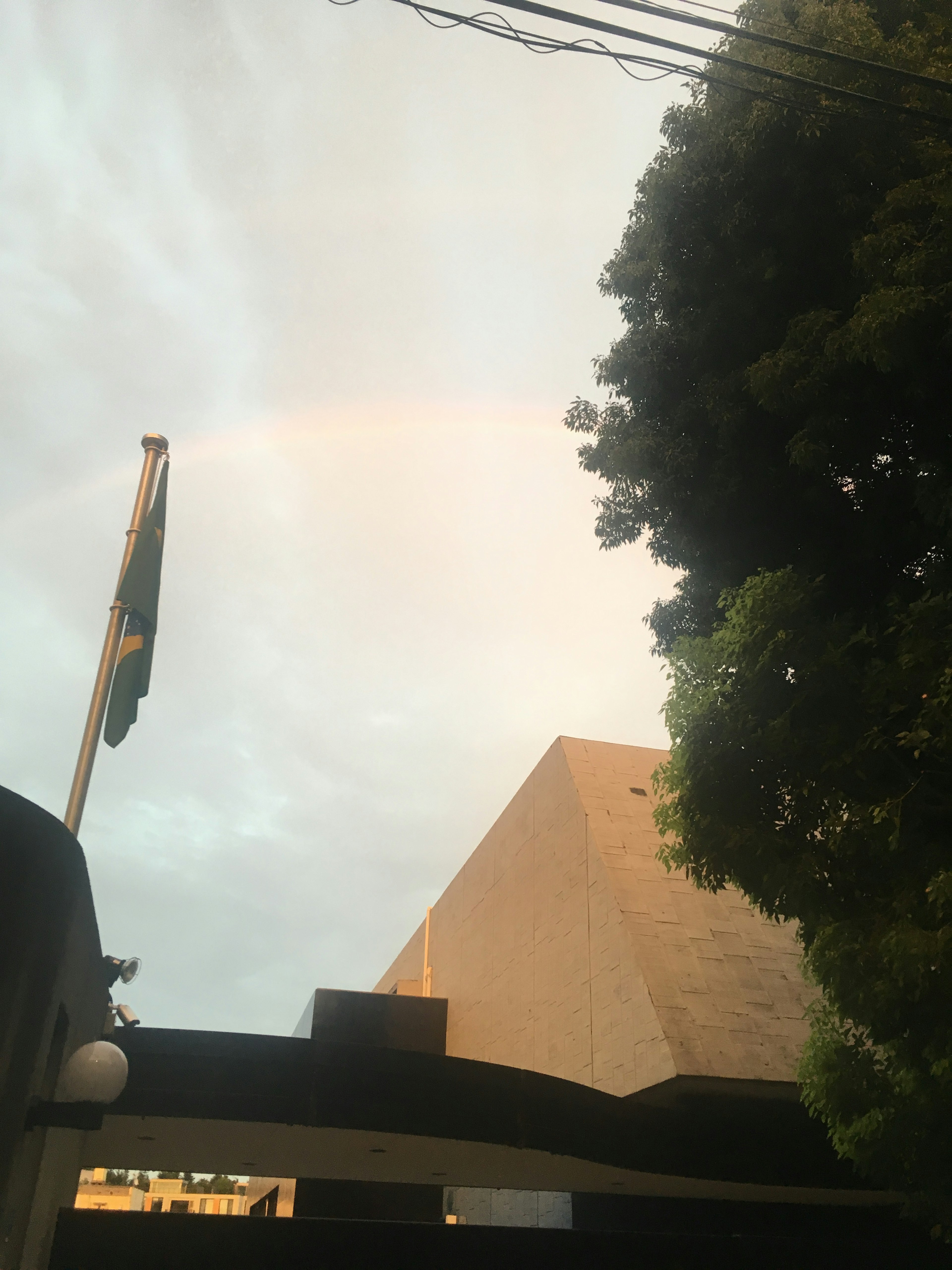 Immagine con un arcobaleno nel cielo e un edificio parzialmente visibile