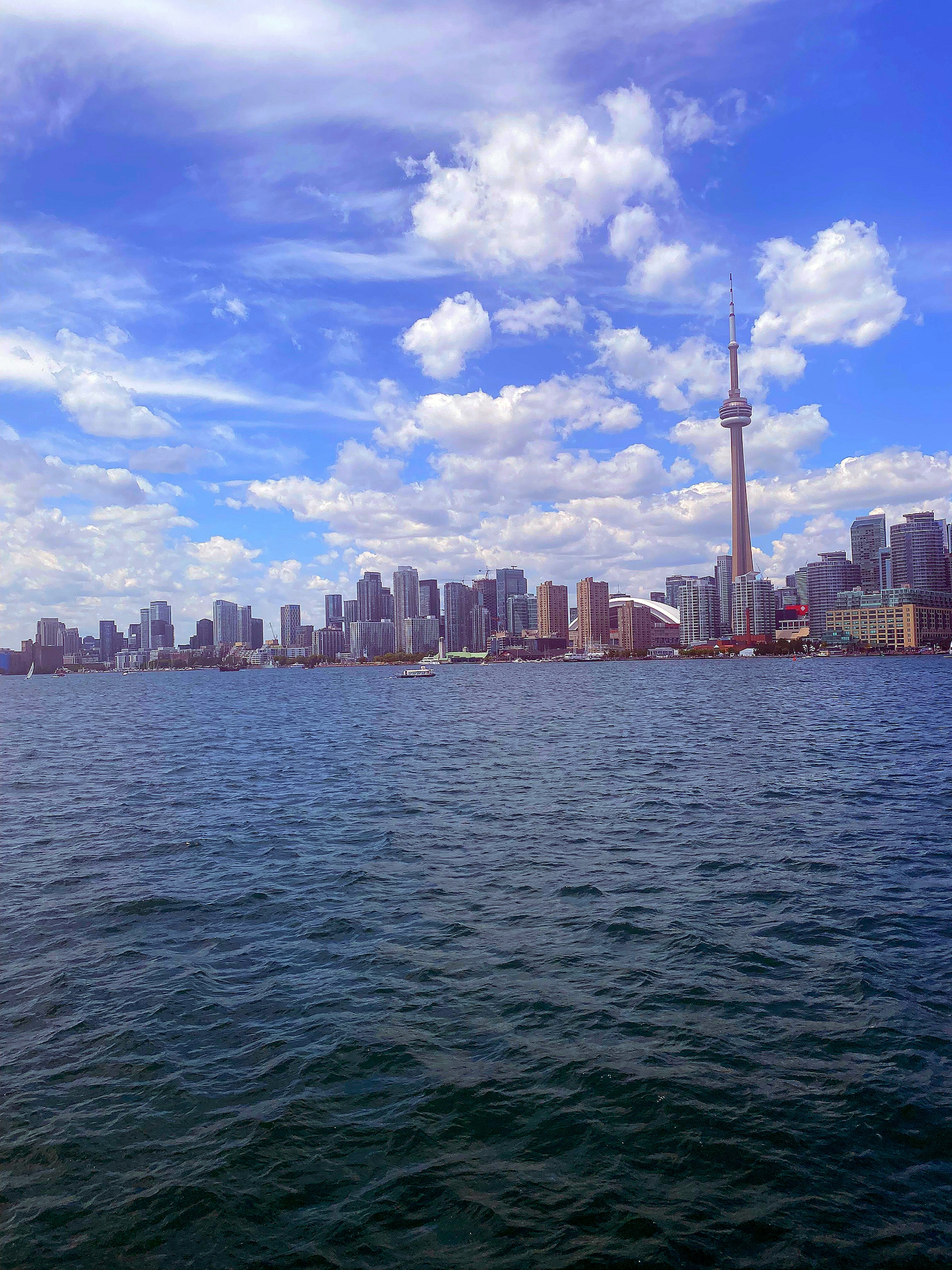 Skyline di Toronto con la CN Tower contro un cielo blu e l'acqua