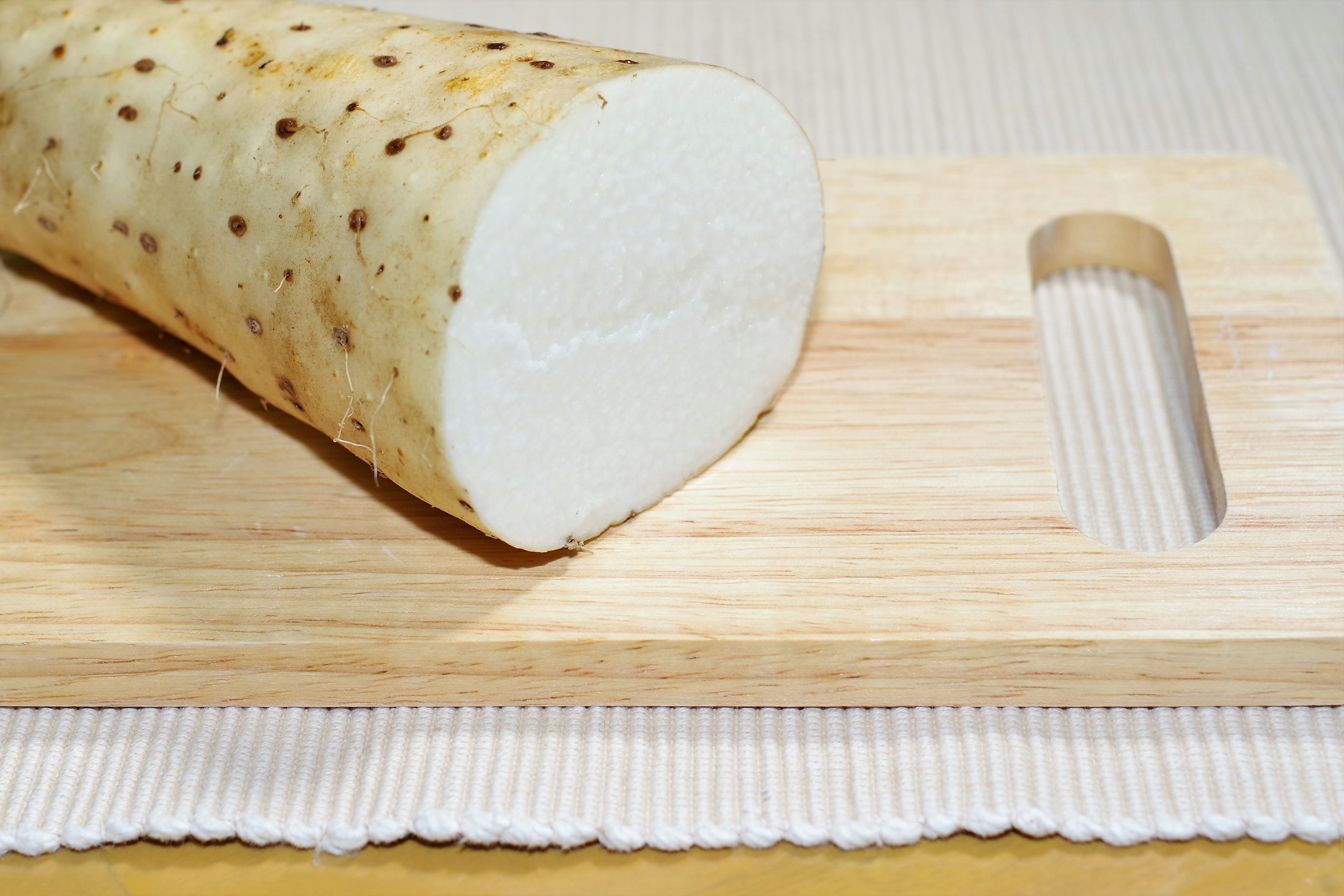 Coupe transversale d'un légume-racine blanc sur une planche à découper en bois