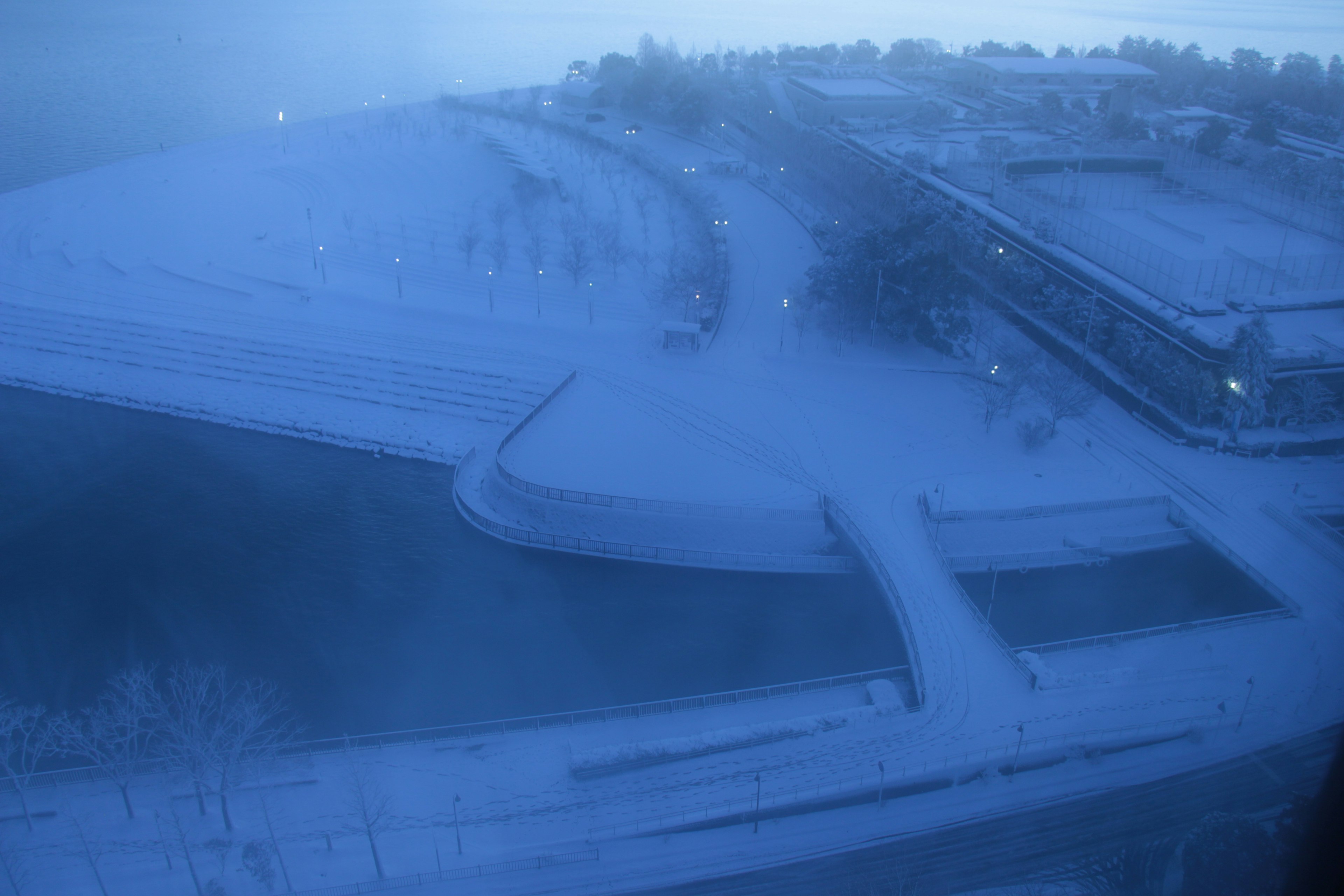 雪に覆われた川の岸辺と建物の風景