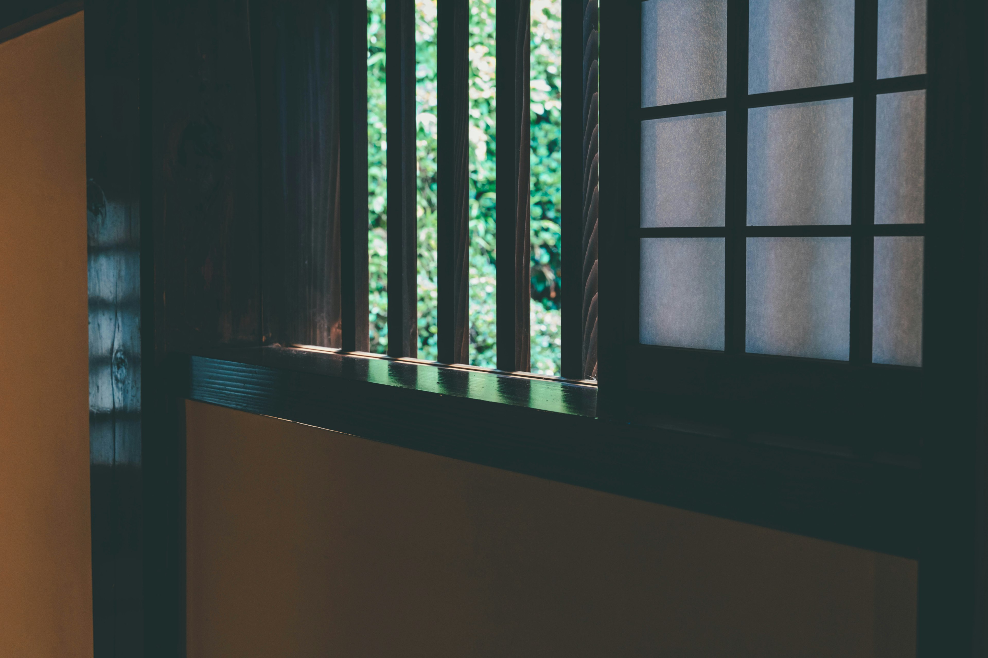 Wooden lattice window with a view of greenery and wall