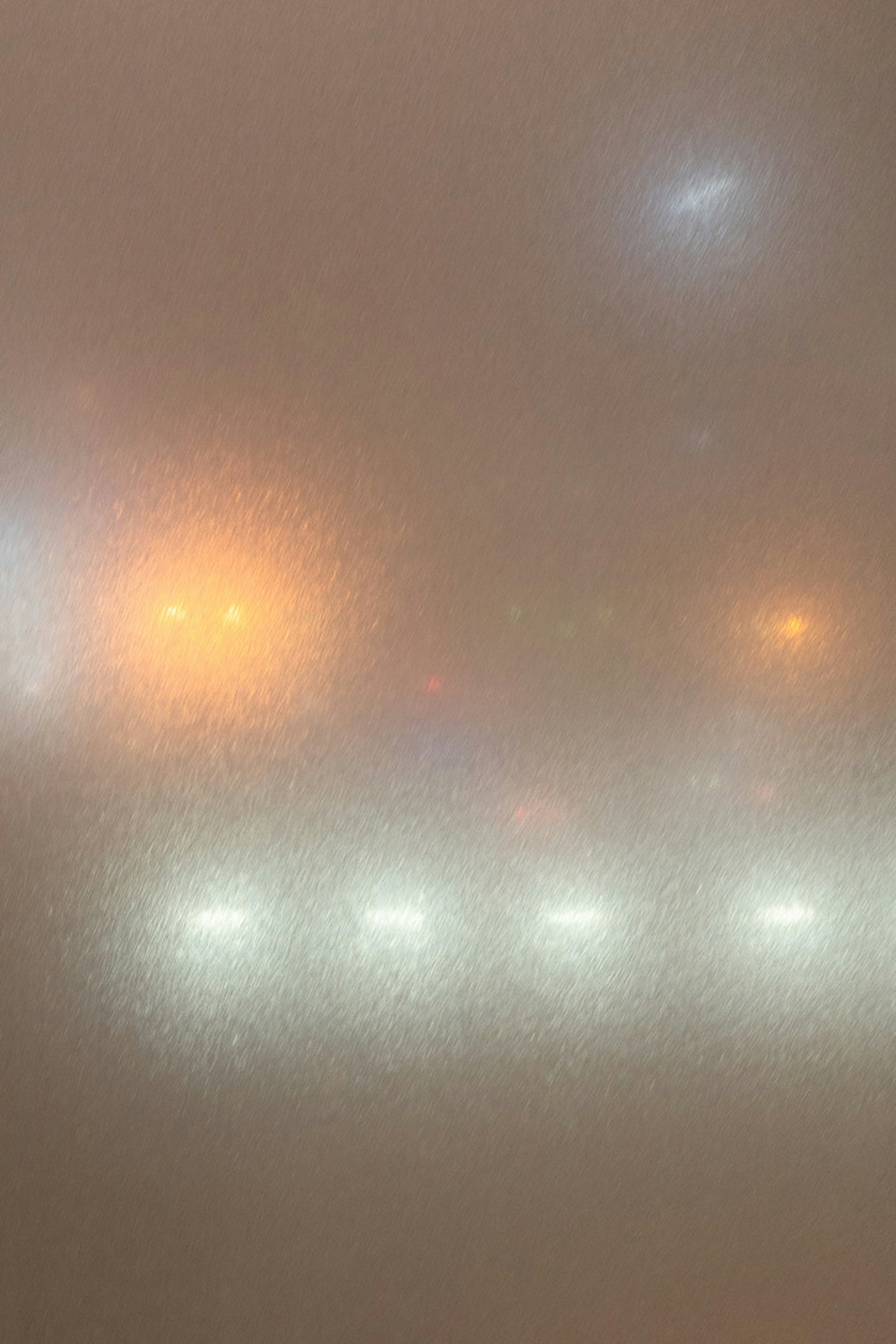 Verschwommene Lichter von Fahrzeugen und Straßenlaternen im Nebel