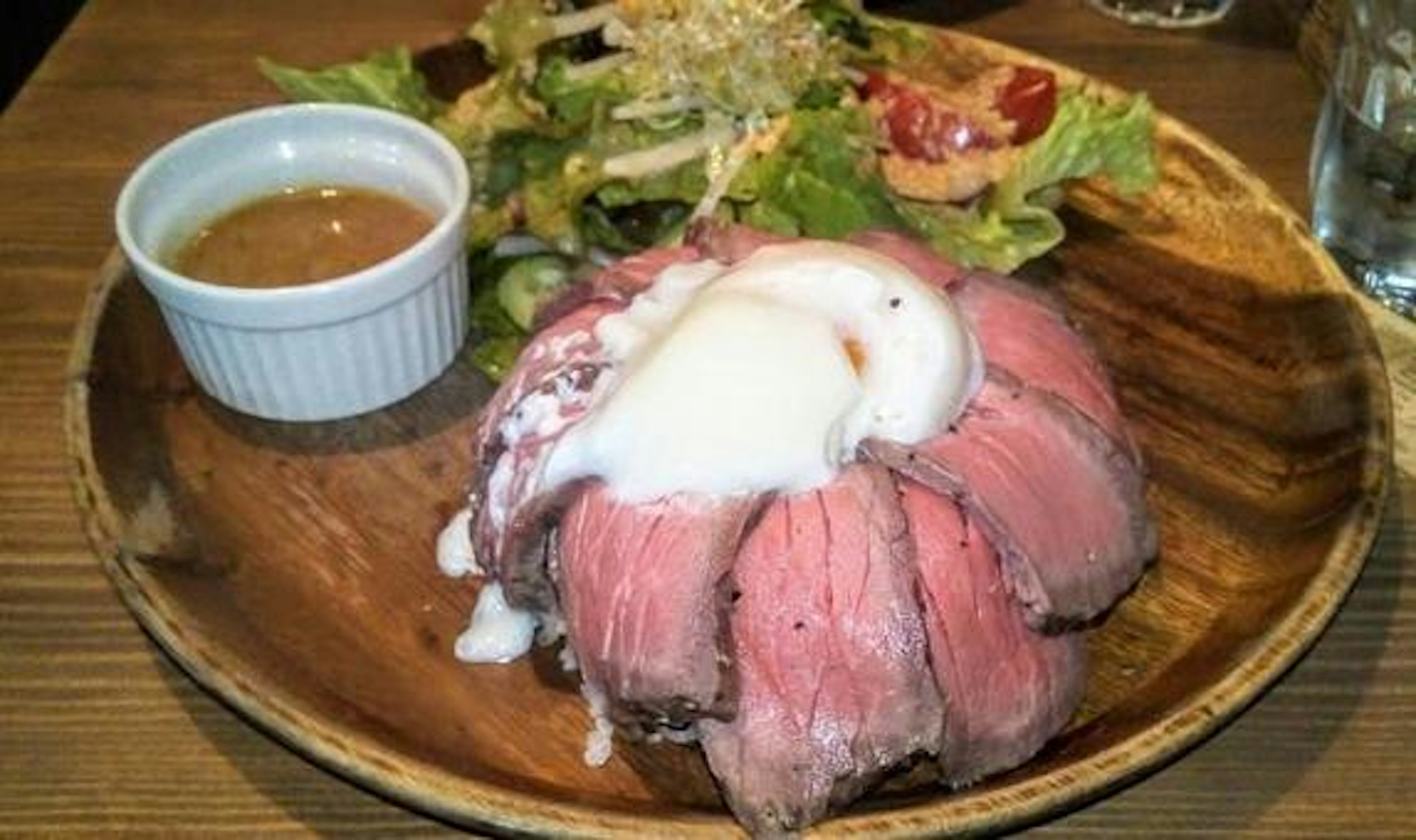 Piatto di roast beef con uovo in camicia e insalata