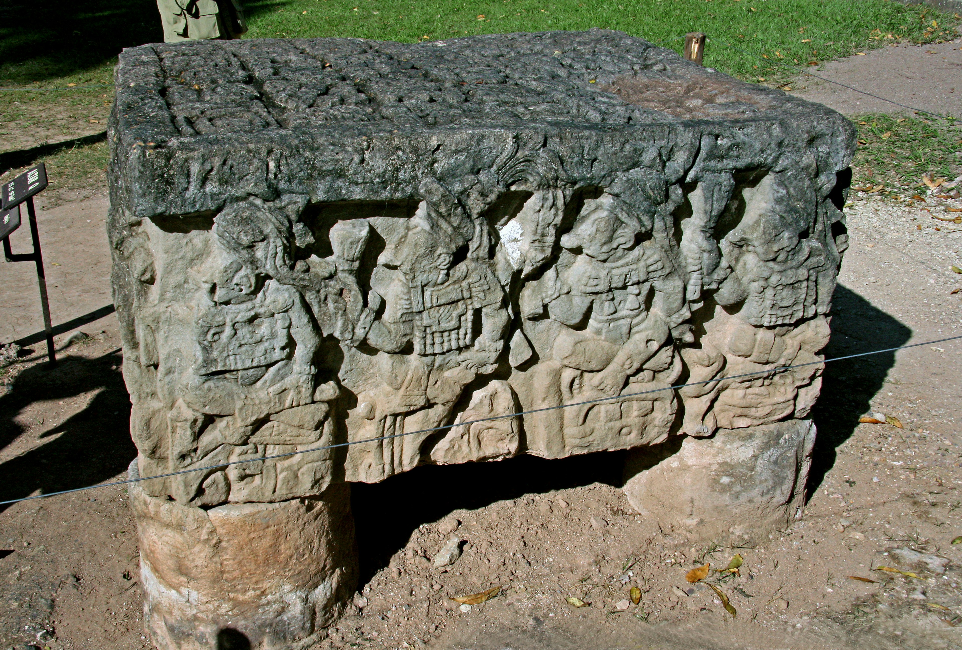 Ancient stone altar with intricate carvings displayed in a park