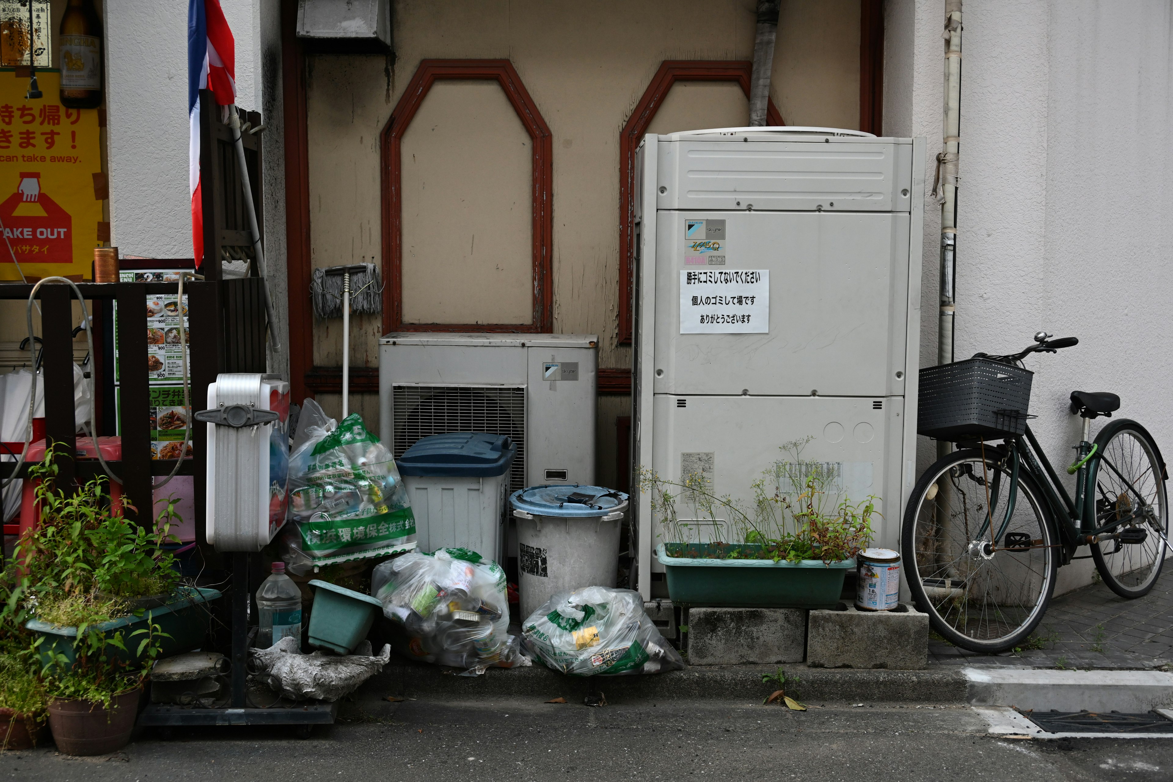 A narrow alleyway scene with a bicycle and garbage bags