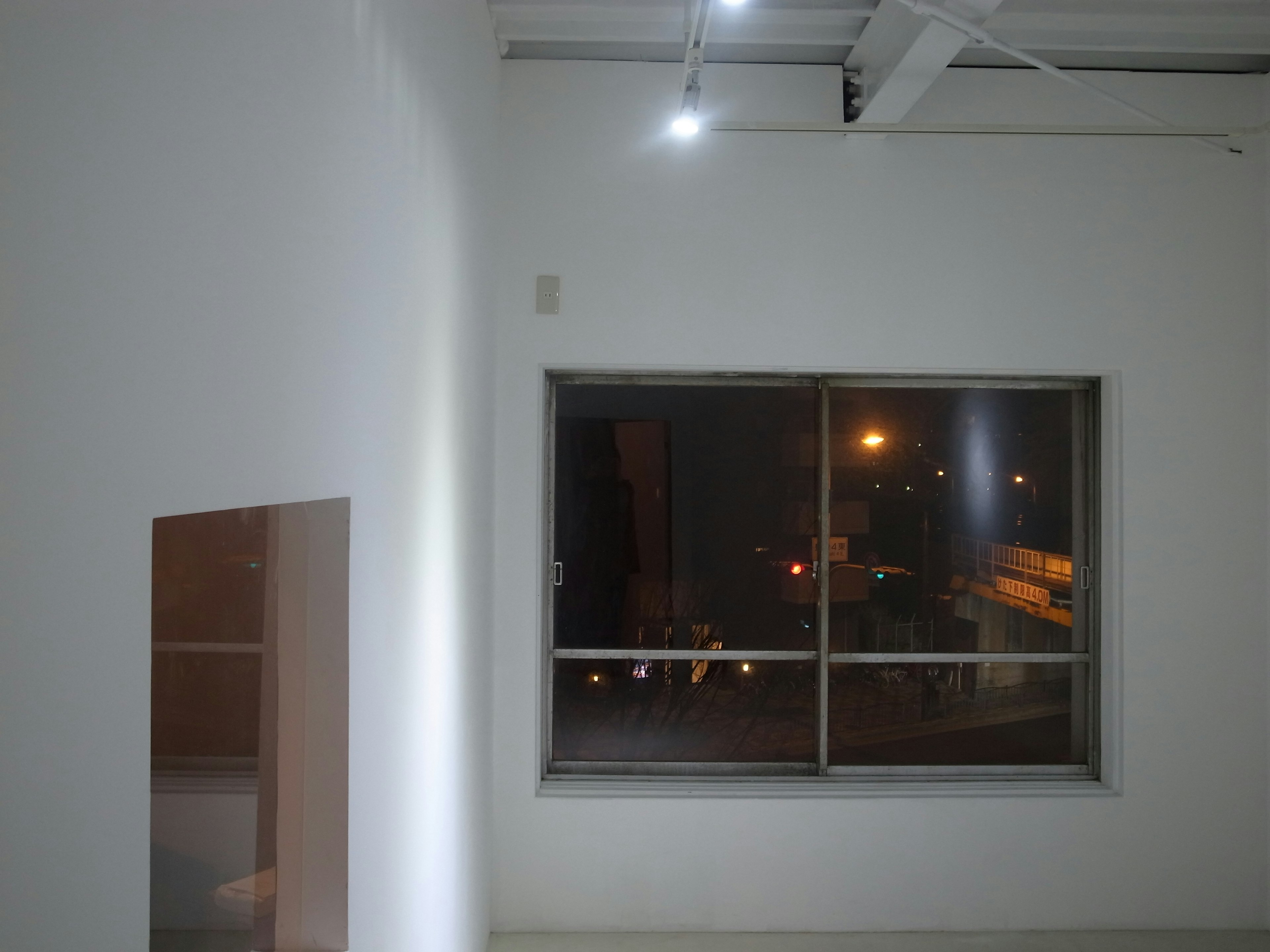 Interior featuring a white wall and a window showing a night view